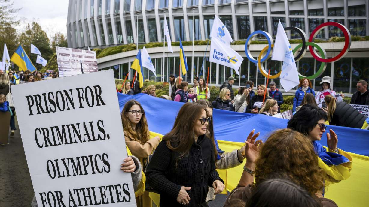 Members of the Geneva branch of Ukrainian society in Switzerland protest during a rally to urge International Olympic Committee to reconsider their decision of participation of Russian and Belarusian athletes under white neutral flag at the next 2024 Paris Olympic Games, in front of the IOC headquarters, in Lausanne, Switzerland, Saturday, March 25, 2023.