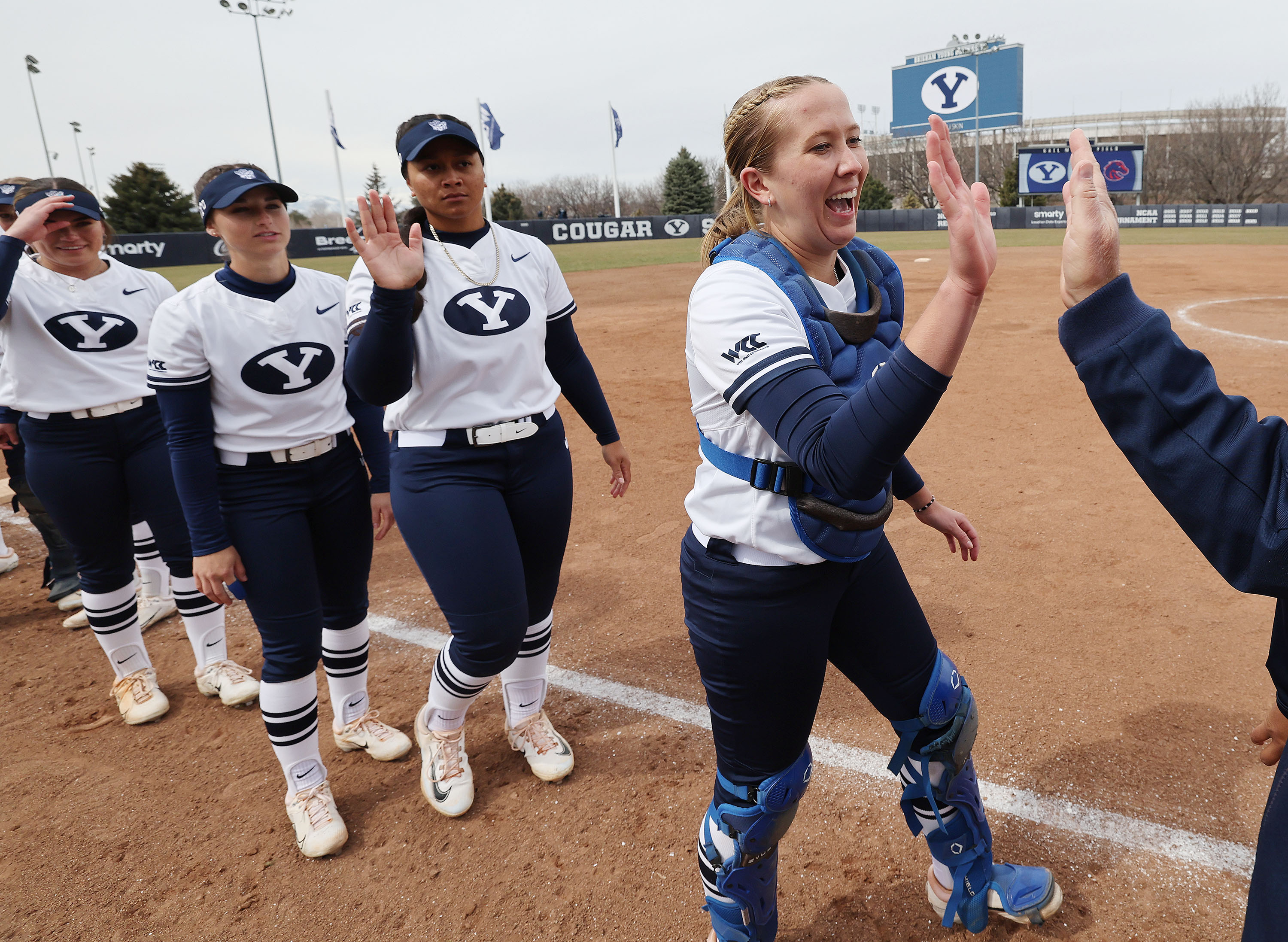 BYU Cougars catcher Hailey Morrow high-fives a coach prior to a game with Boise State in Provo on March 21.