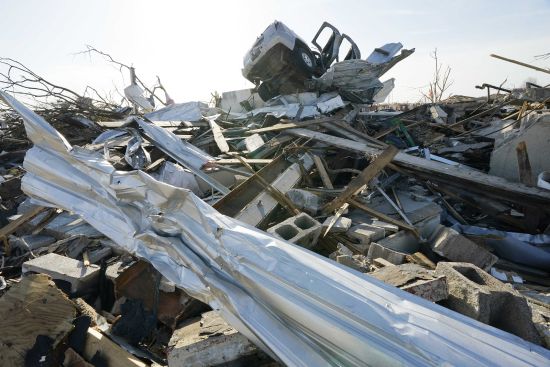 A truck rests atop a building, damaged by the Friday night tornado that hit Rolling Folk, Mississippi, on Sunday morning. Most of the stricken neighborhoods are silent on Sunday morning as the families, friends and neighbors spent Saturday trying to salvage their possessions.