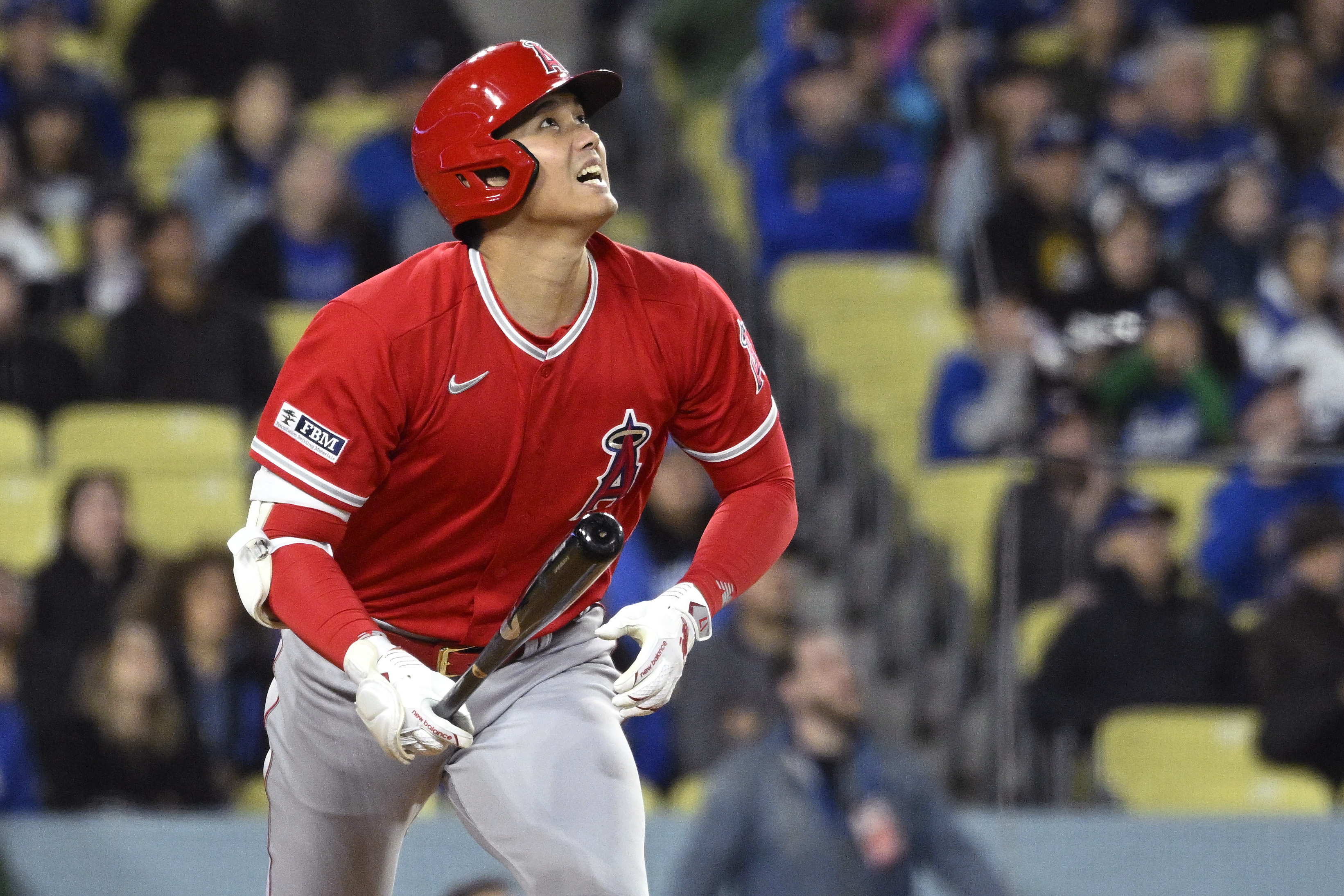 Los Angeles Angels' Shohei Ohtani runs to first as he flies out during the sixth inning of a preseason baseball game against the Los Angeles Dodgers Sunday, March 26, 2023, in Los Angeles.