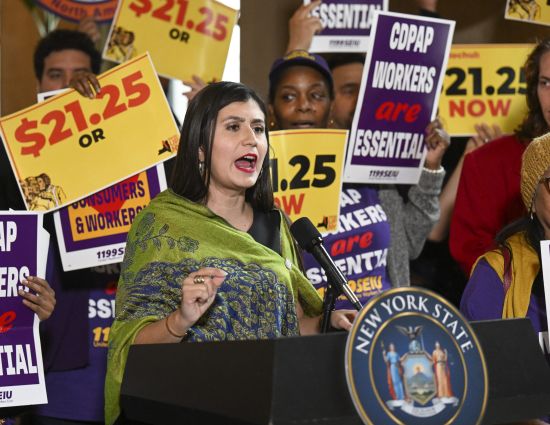 New York Sen. Jessica Ramos, D-East Elmhurst, stands with protesters urging lawmakers to raise New York's minimum wage during a rally at the state Capitol, March 13 in Albany, New York.
