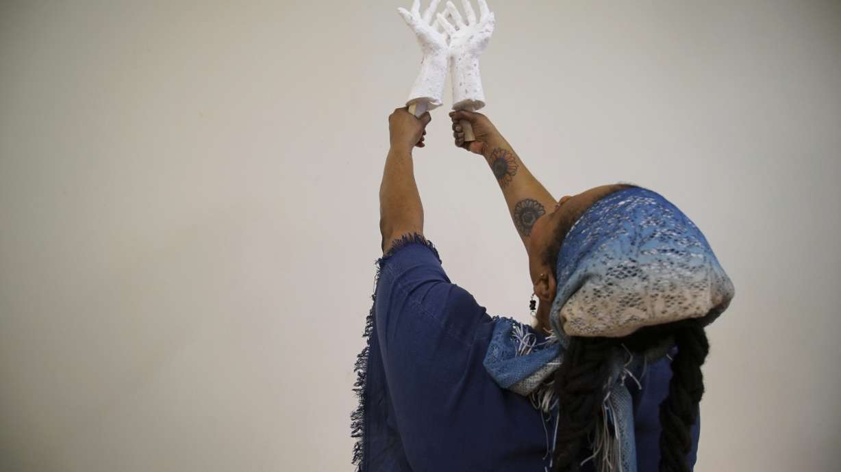 Crystal Kornickey holds up casts of her hands at the Gibbes Museum of Art in Charleston, S.C.. She is one of 36 people whose hands will be cast in bronze for a memorial to the likely enslaved people discovered in an unmarked burial ground.