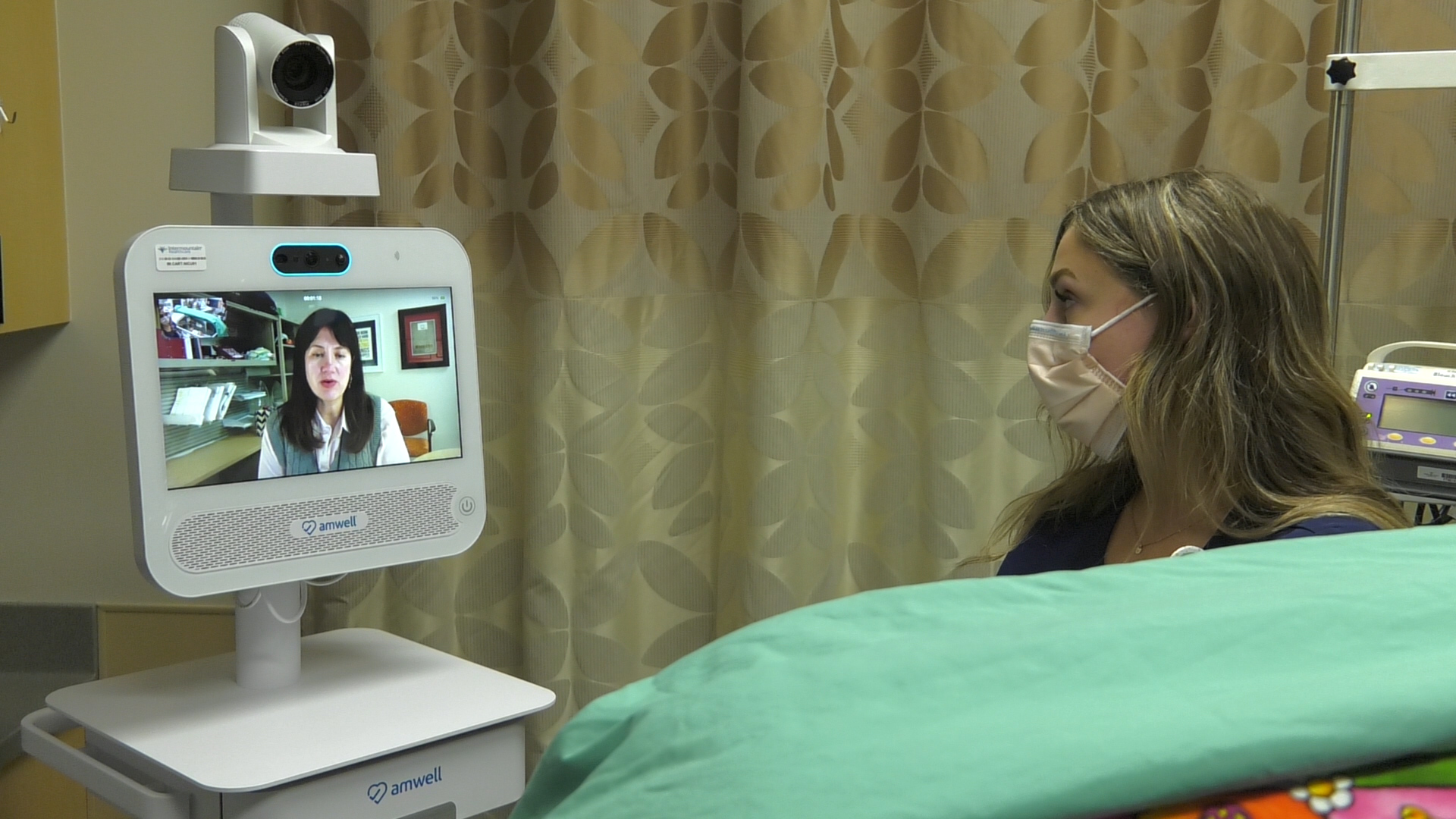 Dr. Betsy Ostrander appears on a screen to help provide neurological care in a NICU, as part of a recently developed Primary Children's Hospital program to help infants outside the hospital.