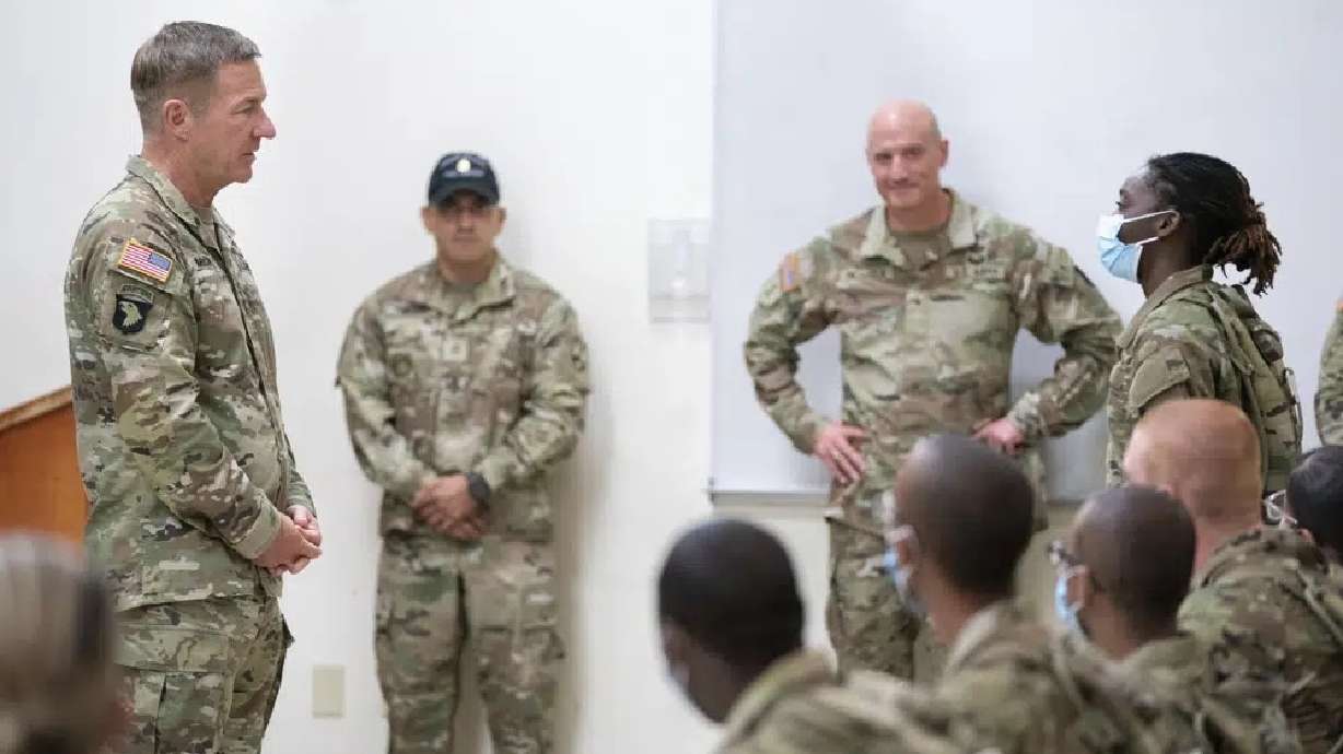 Chief of Staff of the Army Gen. James McConville left, listens to Daysia Holiday, a student in the Future Soldier Prep Course, right, at Fort Jackson in Columbia, South Carolina, Aug. 26, 2022. A new program is giving lower-performing recruits up to 90 days of academic or fitness instruction to help them meet military standards.