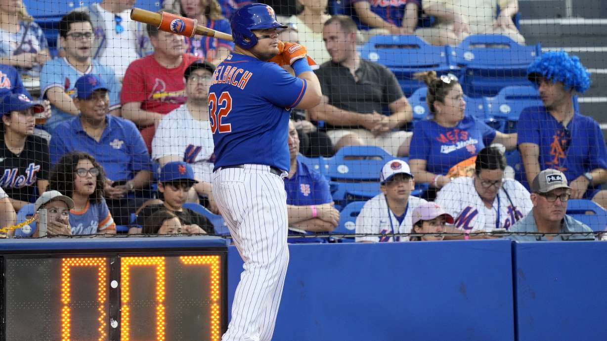 The pitch clock runs as New York Mets' Daniel Vogelbach (32) warms up on deck during the fifth inning of a spring training baseball game against the St. Louis Cardinals, Saturday, March 25, 2023, in Port St. Lucie, Fla.