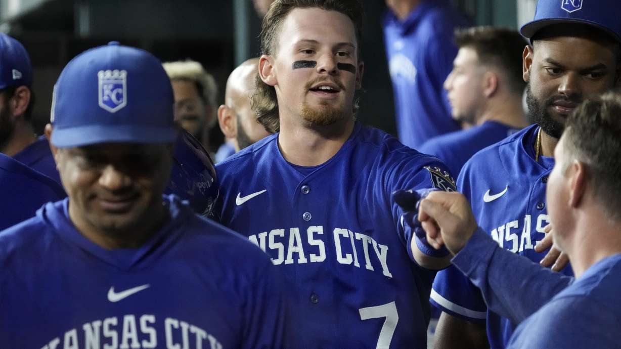 Kansas City Royals Bobby Witt Jr. (7) is congratulated by teammates after hitting a sacrifice fly during the third inning of a spring training baseball game against the Texas Rangers on Monday, March 27, 2023, in Arlington, Texas.