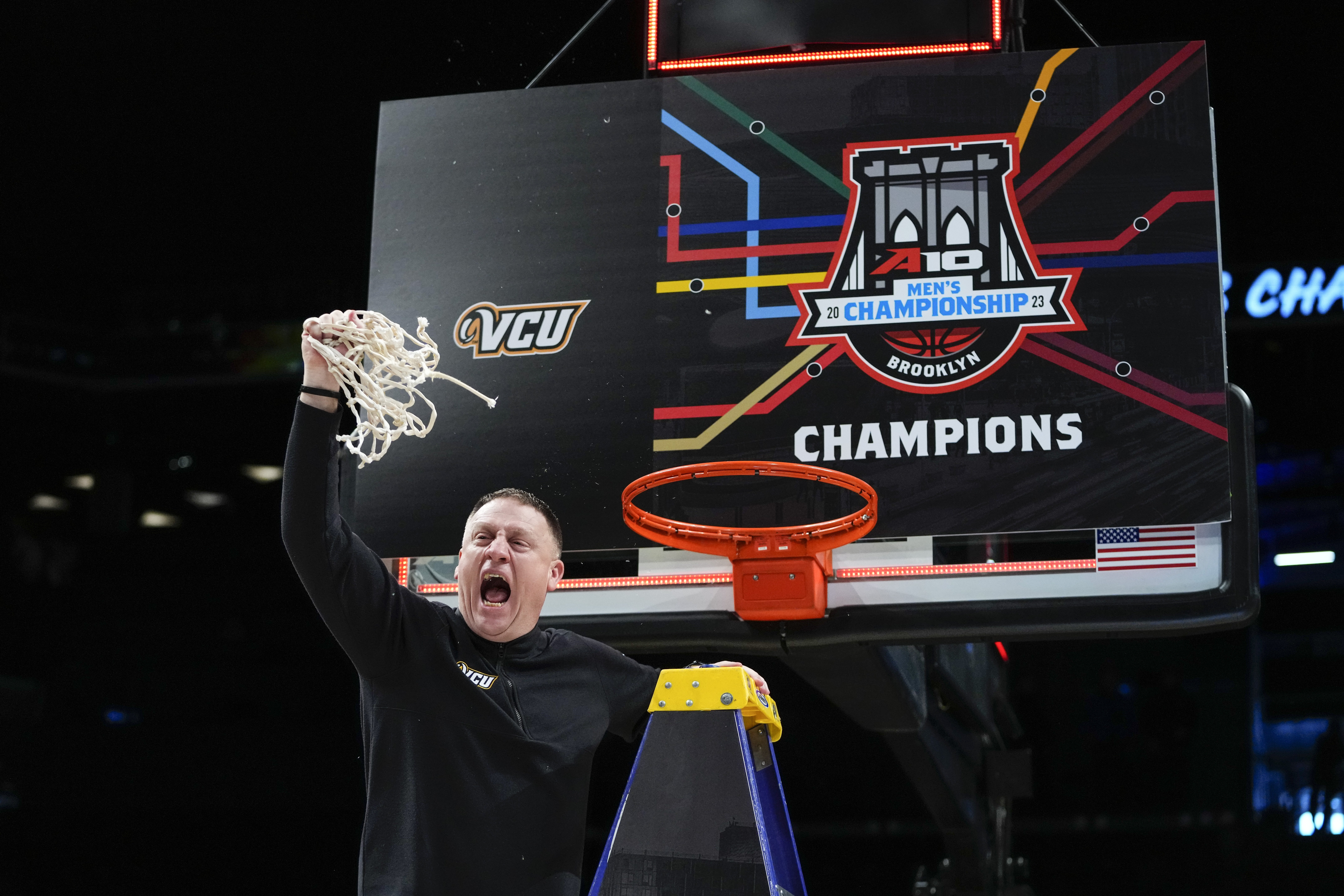Virginia Commonwealth head coach Mike Rhoades celebrates after cutting down the net after an NCAA college basketball game against Dayton in the championship of the Atlantic 10 Conference Tournament, Sunday, March 12, 2023, in New York. Virginia Commonwealth won 68-56.
