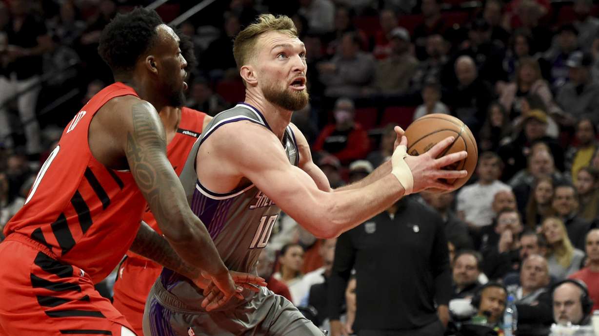 Sacramento Kings forward Domantas Sabonis, right, drives to the basket on Portland Trail Blazers forward Nassir Little, left, during the first half of an NBA basketball game in Portland, Ore., Wednesday, March 29, 2023.