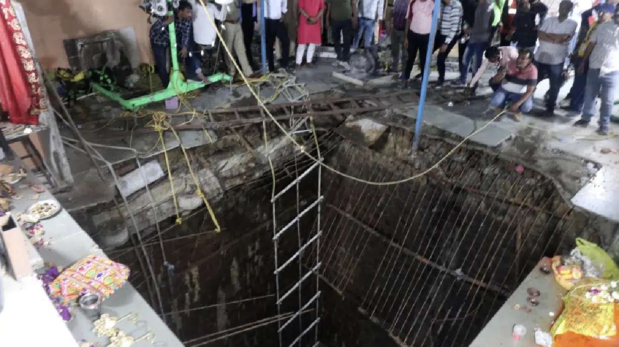 People stand around a structure built over an old temple well that collapsed Thursday as a large crowd of devotees gathered for the Ram Navami Hindu festival in Indore, India, Thursday.