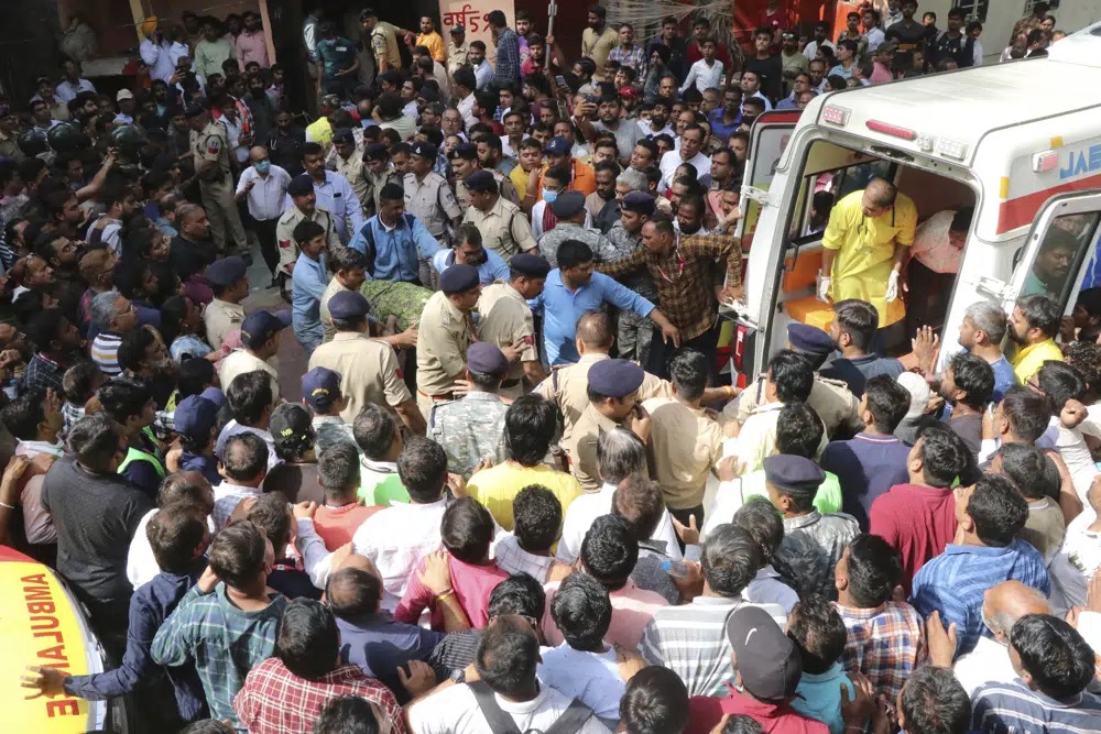 An accident victim is carried towards a waiting ambulance in Indore, India, Thursday. A structure built over an old temple well in India collapsed Thursday as a large crowd of devotees prayed at a festival for Rama, one of the most widely worshipped Hindu deities, killing at least eight people, police said.