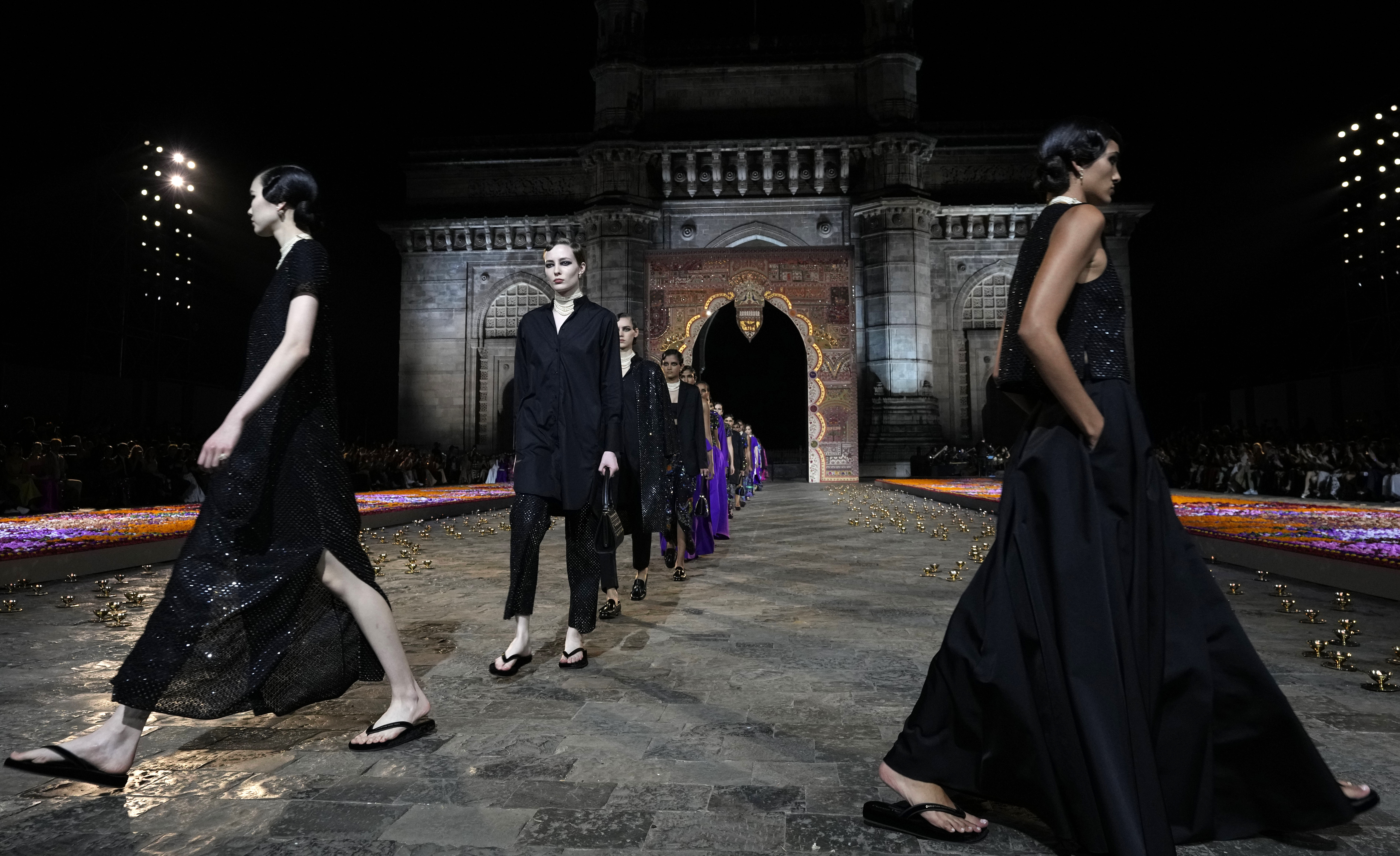 Models display creations for the Dior Pre-Fall 2023 collection at the Gateway of India landmark monument in Mumbai, India, Thursday, March 30, 2023.