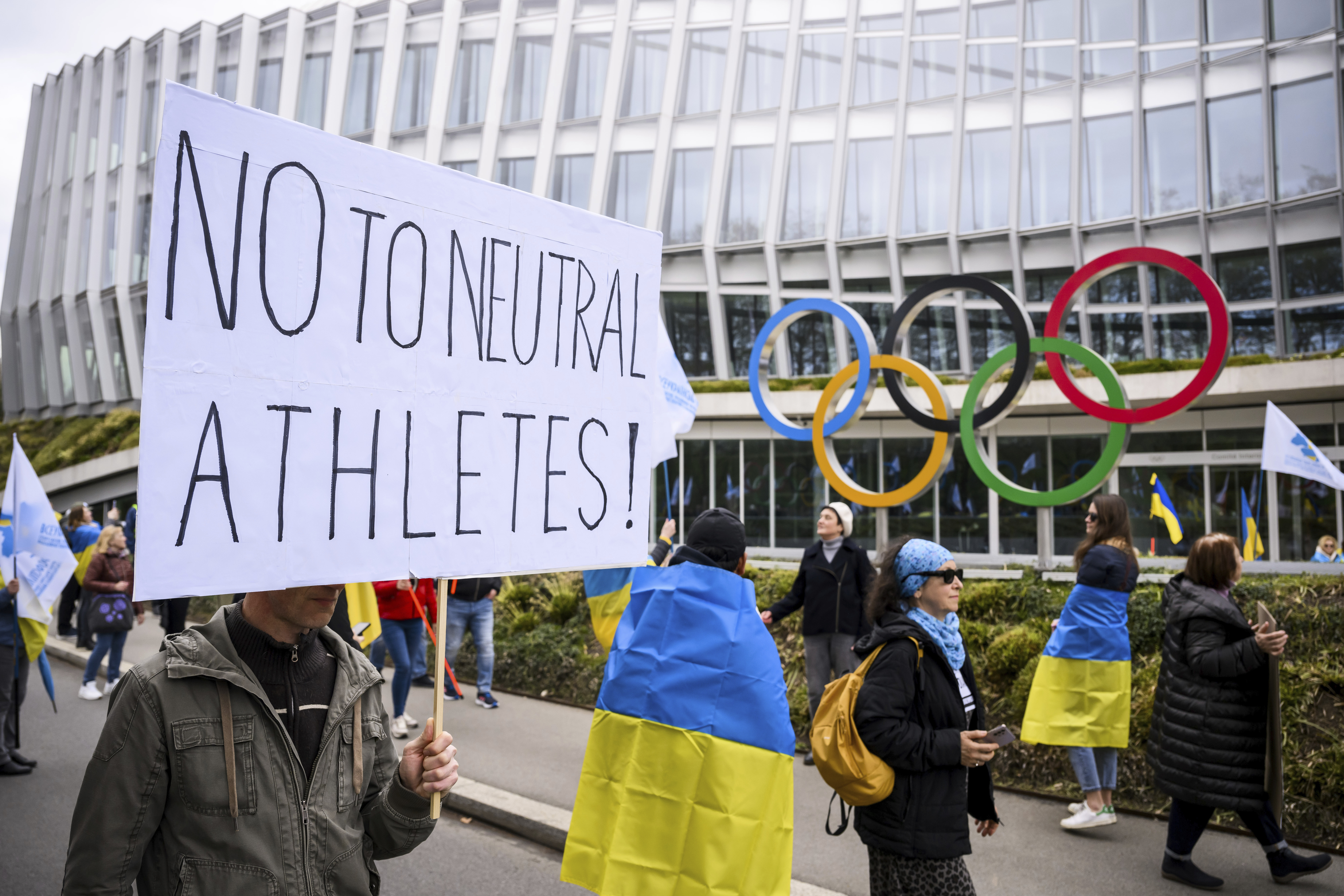 Members of the Geneva branch of Ukrainian society in Switzerland protest during a rally to urge International Olympic Committee to reconsider their decision of participation of Russian and Belarusian athletes under white neutral flag at the next 2024 Paris Olympic Games, in front of the IOC headquarters, in Lausanne, Switzerland, Saturday, March 25, 2023.
