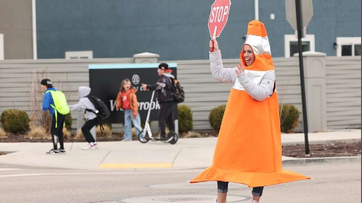 Whitney Durfee works as a crossing guard outside Trailside Elementary School in Vineyard on Friday. Durfee started dressing as a traffic cone to raise awareness for the importance of avoiding distracted driving and speeding in school zones.