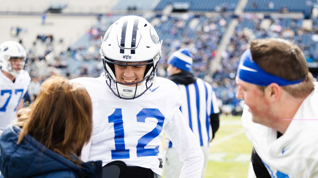 BYU Cougars quarterback Jake Retzlaff (12) laughs with a trainer during the annual BYU Blue vs. White scrimmage at LaVell Edwards Stadium in Provo on Friday, March 31, 2023.