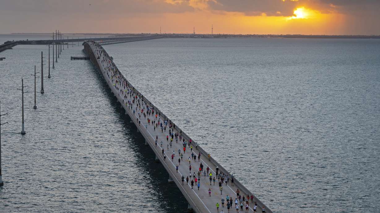 In this photo provided by the Florida Keys News Bureau, the sun rises above the Atlantic Ocean in the Florida Keys as a field of 1,500 competitors traverses the Seven Mile Bridge from Little Duck Key to Marathon, Fla., Saturday, April 1, 2023. The annual Seven Mile Bridge Run shut down the longest bridge on the Florida Keys Overseas Highway to traffic for three hours Saturday morning for the race over the convergence of the Atlantic Ocean and Gulf of Mexico. Joanna Stephens, 28, of Atlanta won the overall women's title and Vaclav Bursa, 15, of Big Pine Key, Fla., won the overall men's division.