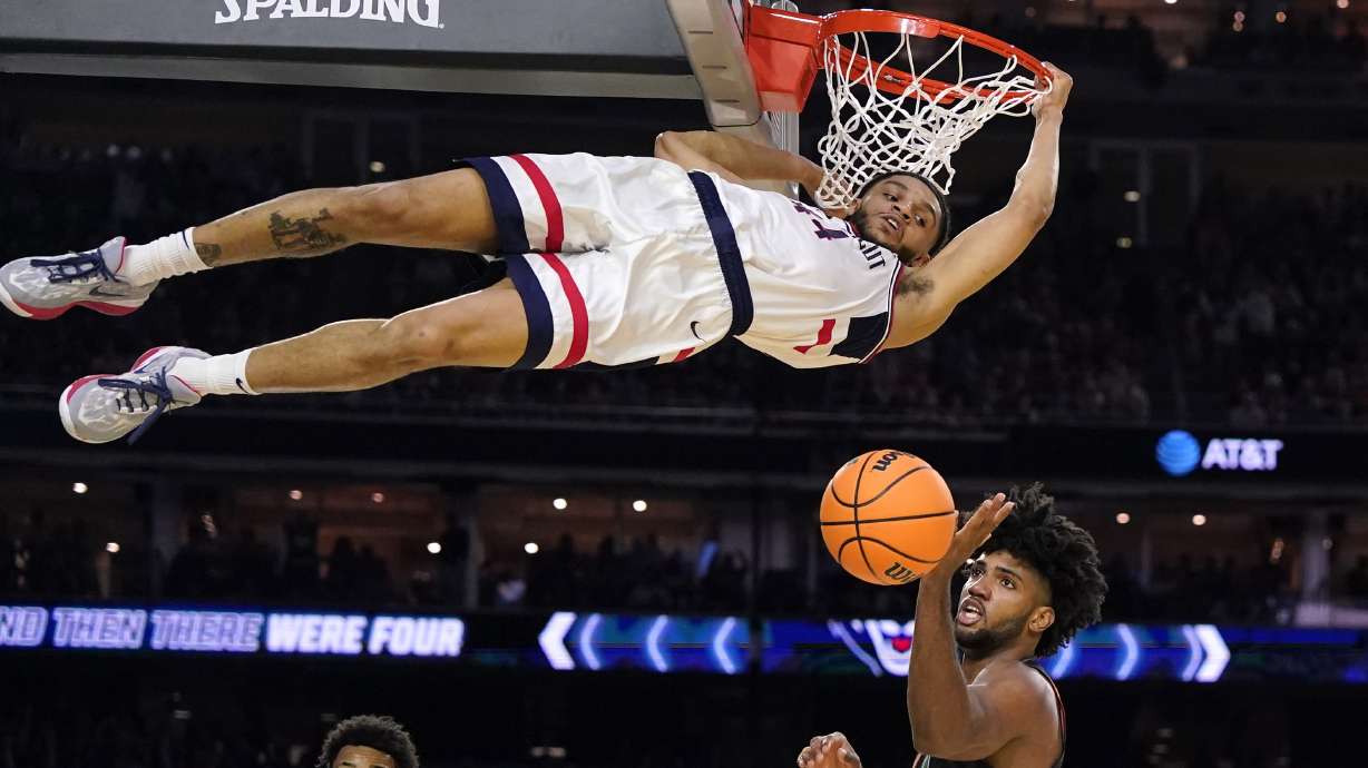 Connecticut guard Andre Jackson Jr. dunks the ball over Miami forward Norchad Omier, right, during the second half of a Final Four college basketball game in the NCAA Tournament on Saturday, April 1, 2023, in Houston.