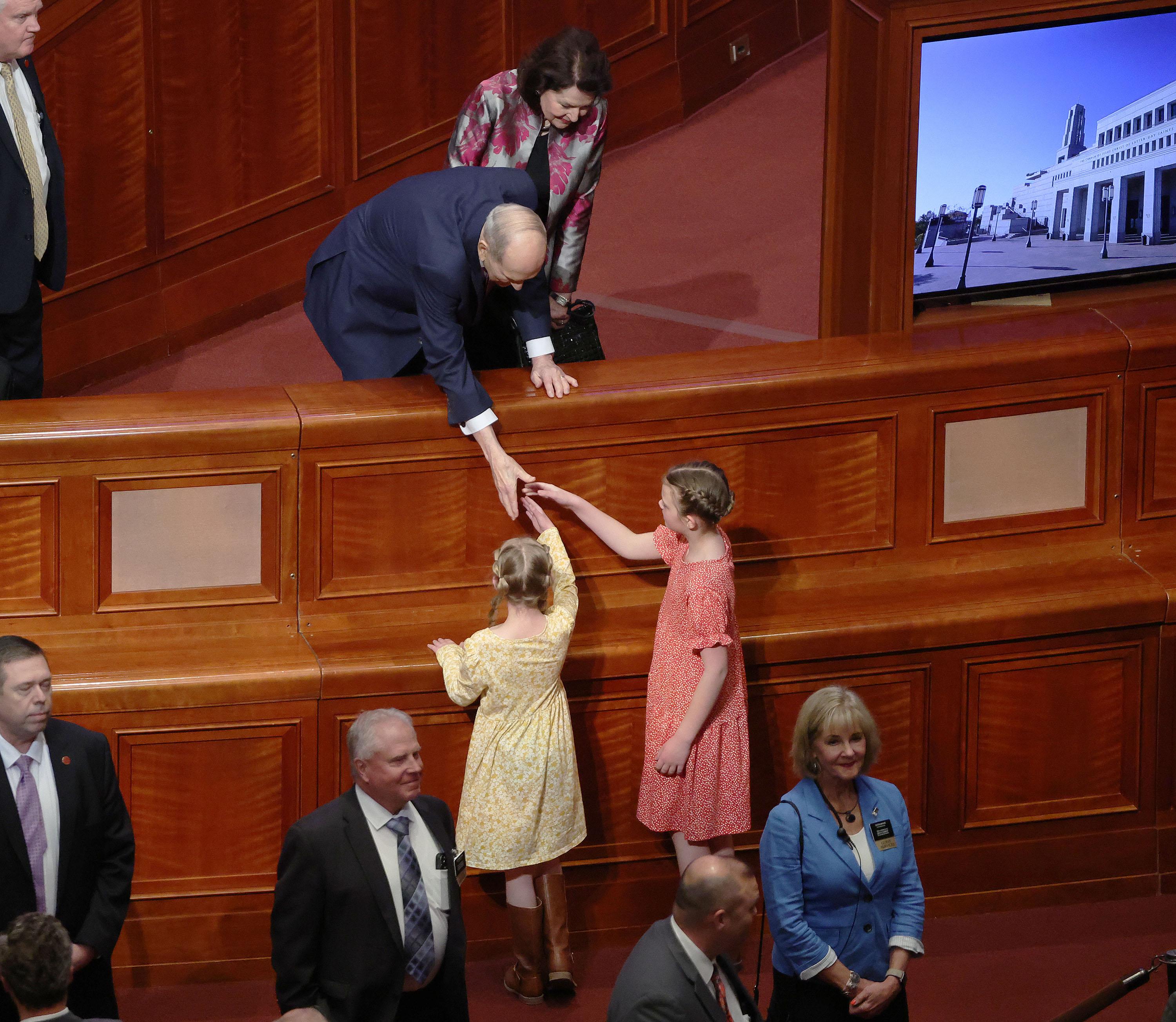 President Russell M. Nelson of The Church of Jesus Christ of Latter-day Saints shakes hands with a young girls after the Sunday morning session of general conference in the Conference Center.