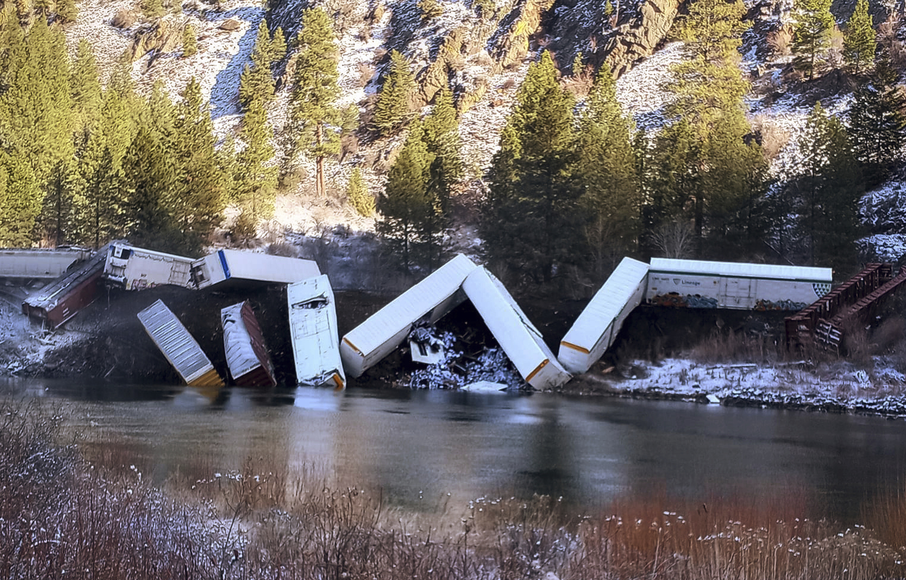 A train derailed along the Clark Fork River near Paradise, Mont., Sunday. Authorities say about 25 train cars derailed. 