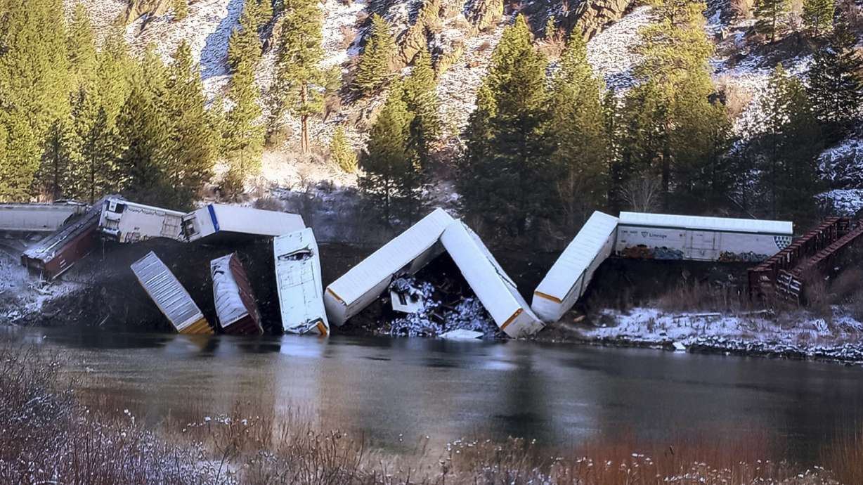 A train derailed along the Clark Fork River near Paradise, Mont., Sunday. Authorities say about 25 train cars derailed.