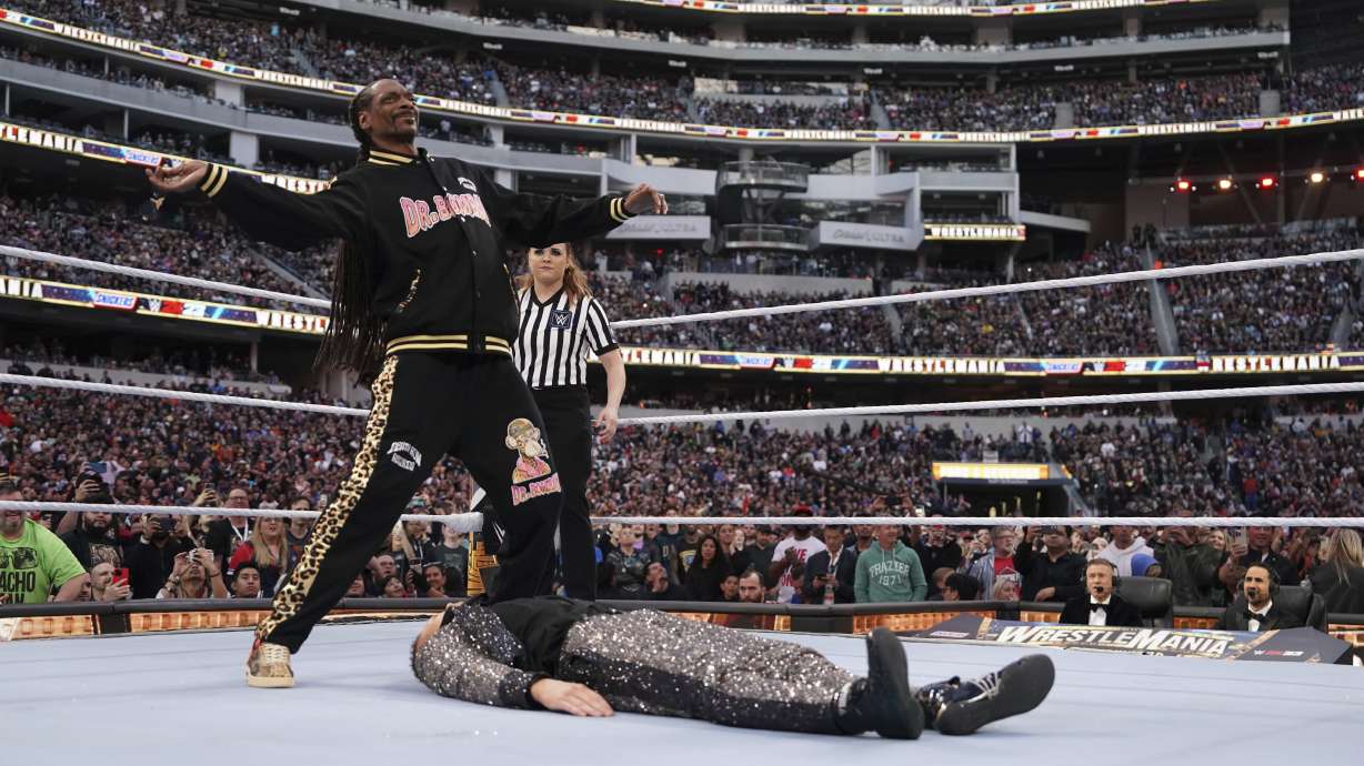 In this photo provided by WWE, rapper Snoop Dogg gets ready to drop The People's Elbow on Mike "The Miz" Mizanin during WrestleMania 39 on Sunday, April 2, 2023, at SoFi Stadium in Inglewood, Calif. The rapper stepped in at the last second to perform in the match after Shane McMahon was injured.