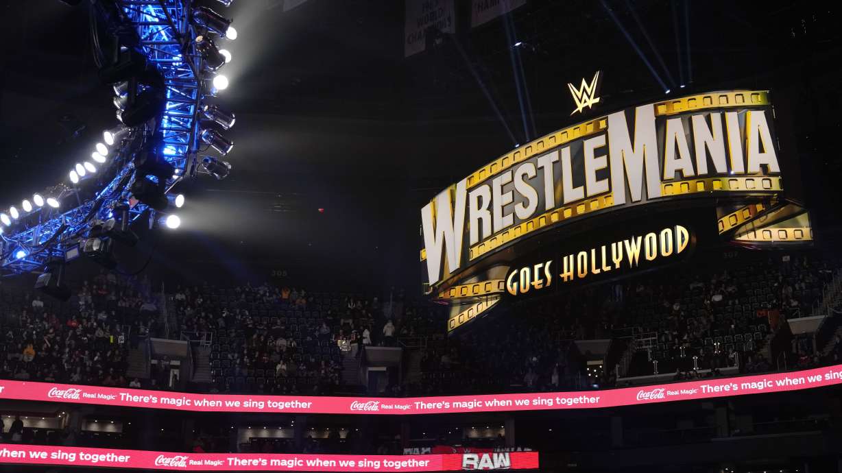 A WrestleMania sign hangs over the crowd during the WWE Monday Night RAW event, Monday, March 6, 2023, in Boston. WWE’s WrestleMania arrives this weekend, Saturday, April 1, to a massive audience and vastly larger advertising revenue as it seeks to establish itself as a serious contender for major advertising bucks.