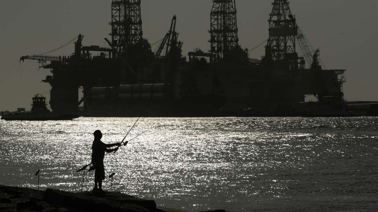 A man fishes near an oil drilling platform on May 8, 2020, in Port Aransas, Texas. Offshore oil and gas operations in the Gulf of Mexico are releasing far more climate-changing methane than official estimates show, according to a new study published Monday.