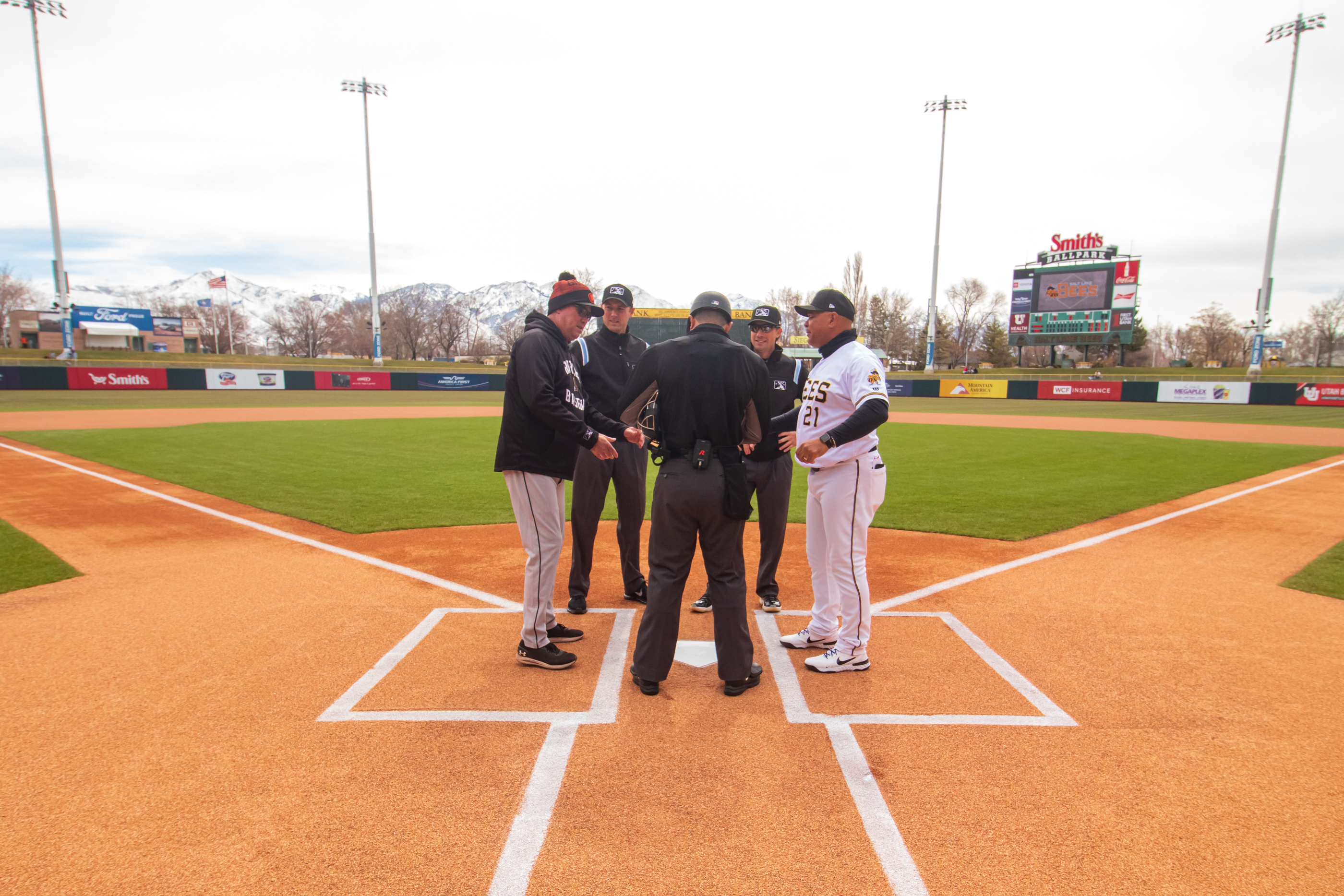 Salt Lake Bees managers Keith Johnson, right, and Sacramento River Cats manager Dave Brundage, left, exchange lineup cards with umpires before a game at Smith's Ballpark on Saturday. Johnson said he prefers an automatic ball-strike challenge system over a complete computer overhaul of home plate umpiring.