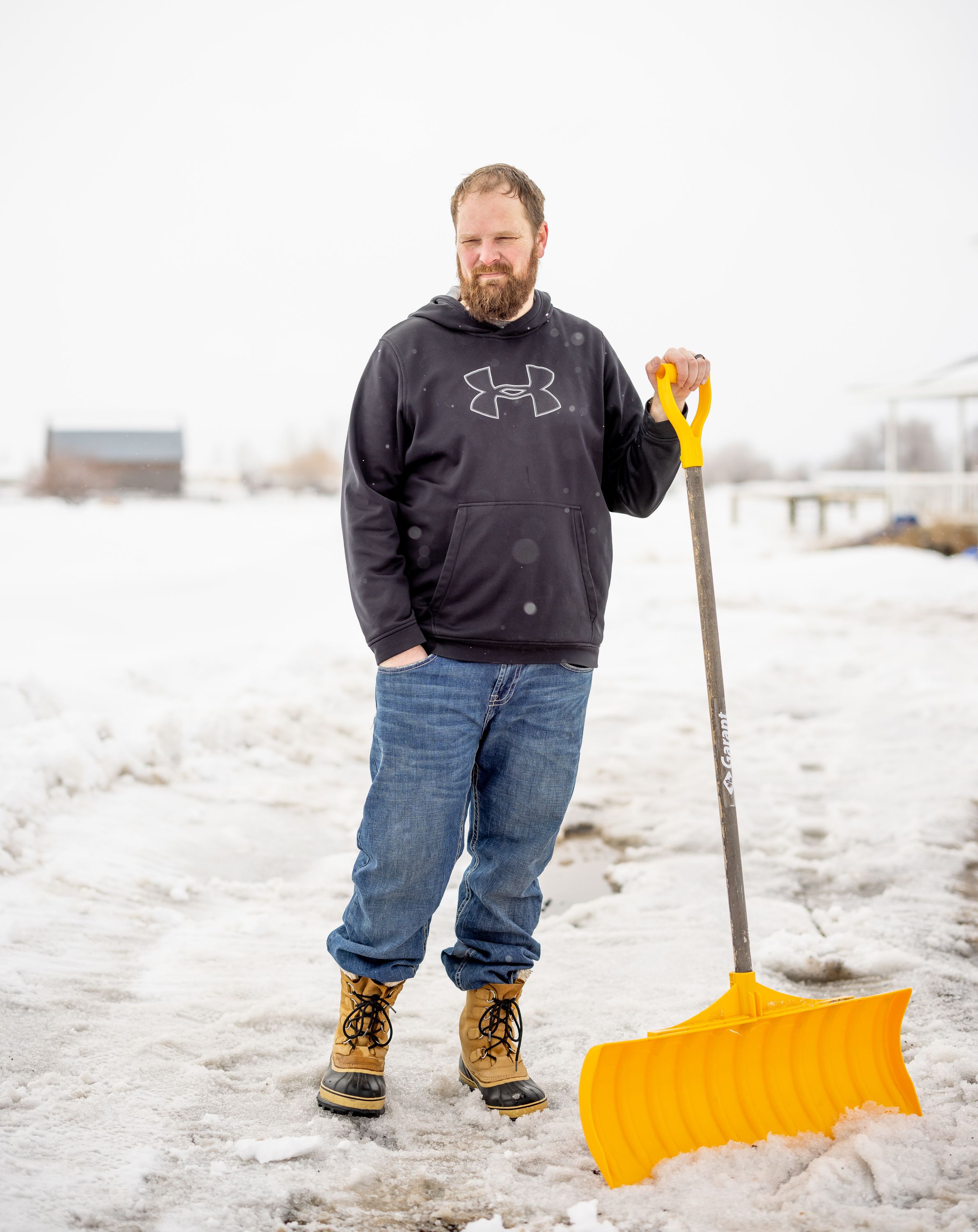 Chris Tunnell, 47, pauses from shoveling his driveway on March 30, at his home in Salem, Idaho, just down the street from Chad Daybell’s property.