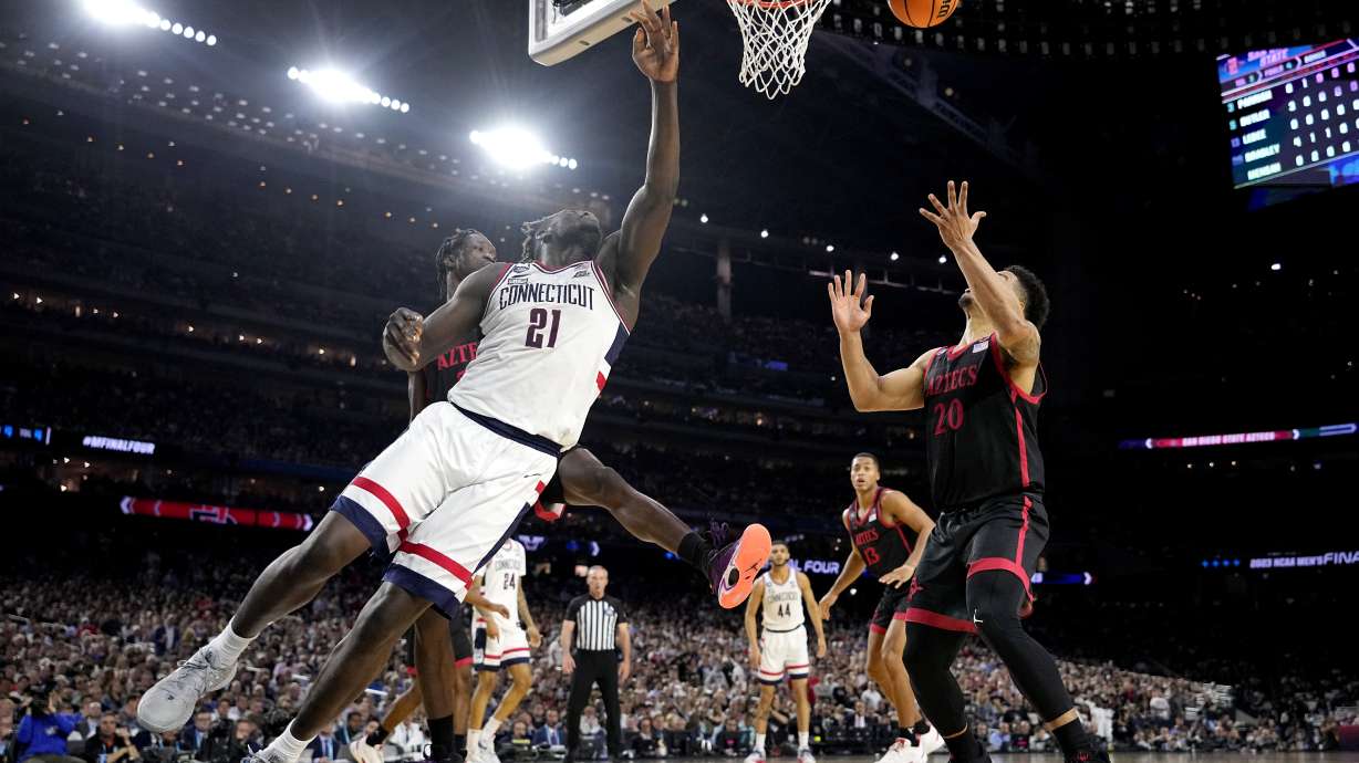Connecticut forward Adama Sanogo (21) and San Diego State guard Matt Bradley vie for a rebound during the first half of the men's national championship college basketball game in the NCAA Tournament on Monday, April 3, 2023, in Houston.