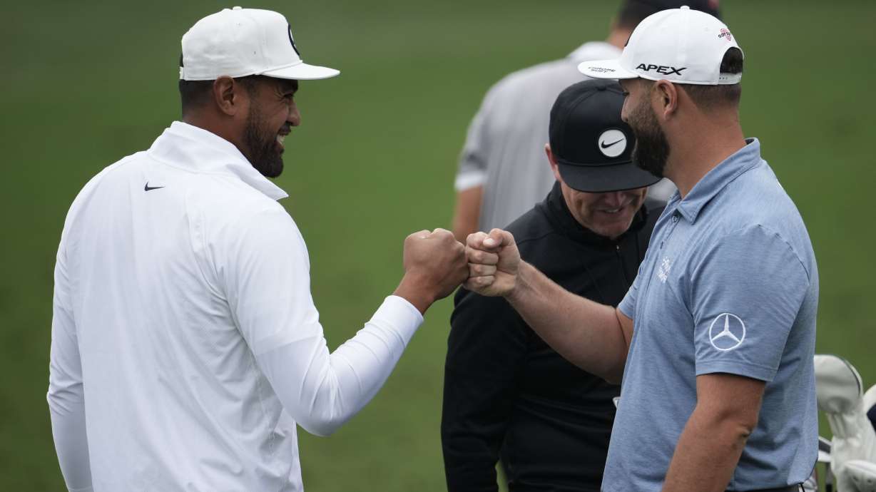 Tony Finau, left, speaks with Jon Rahm, of Spain, on the range during a practice for the Masters golf tournament at Augusta National Golf Club, Tuesday, April 4, 2023, in Augusta, Ga.