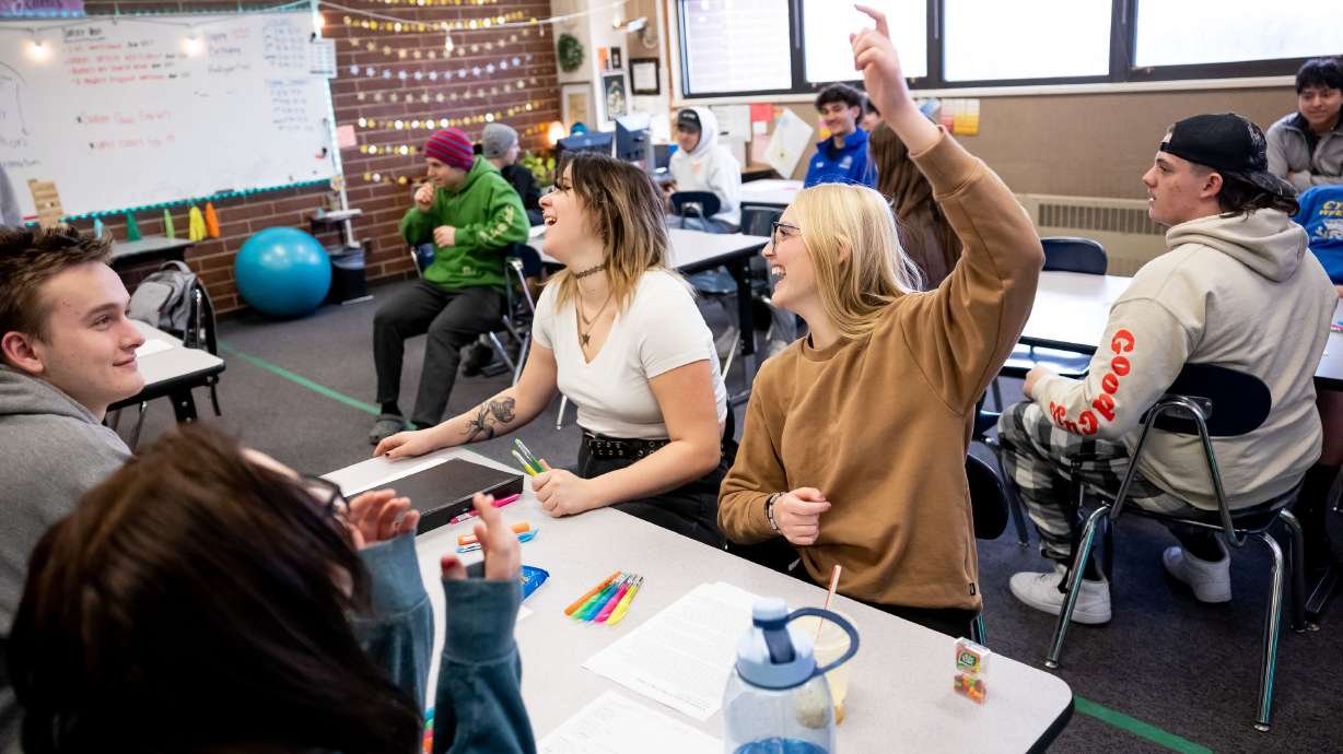 Tori Poulsen, 18, center, and Lily Williams, 17, right, laugh during a review game being played in their English class at Cyprus High School in Magna on Jan. 27.