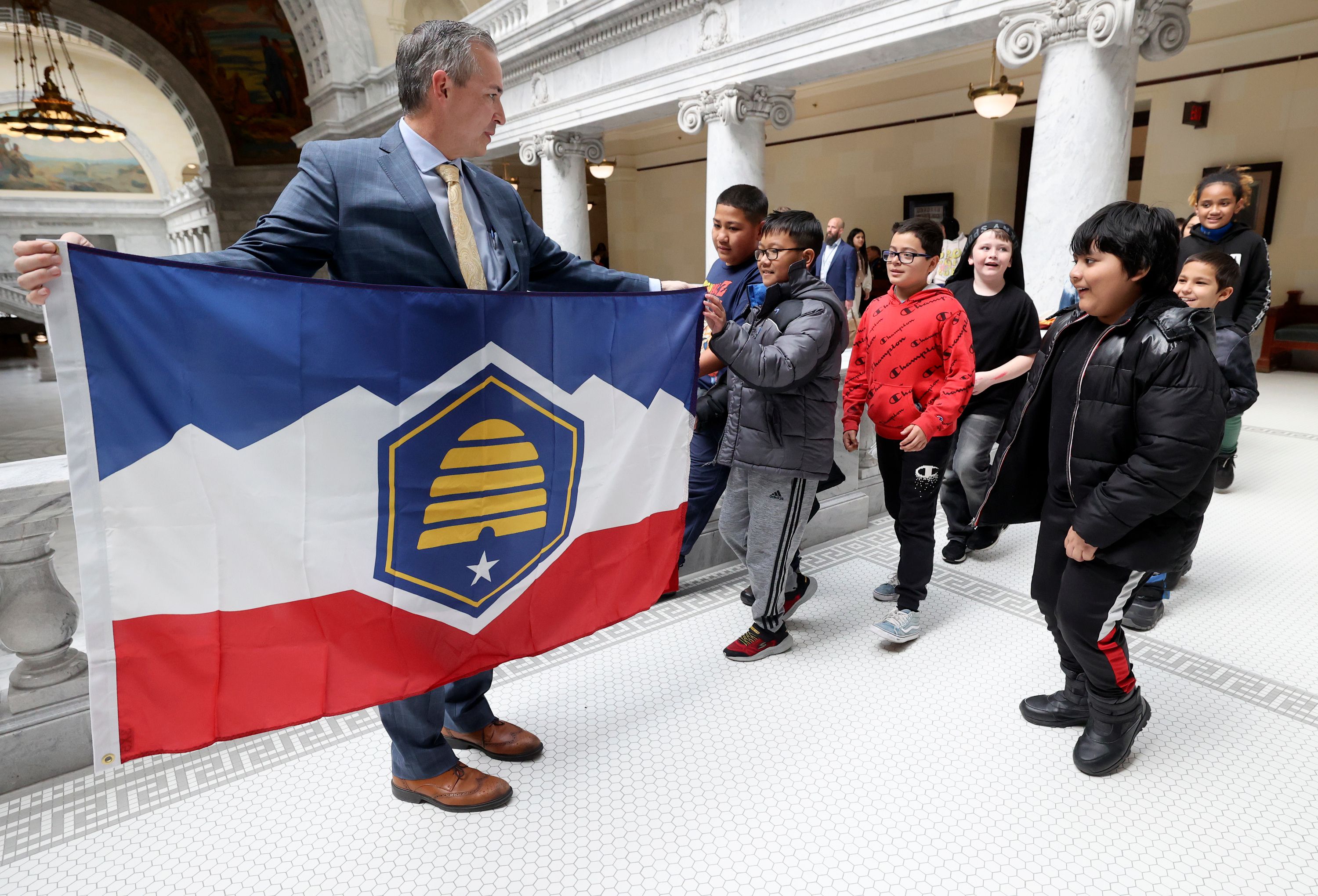 Sen. Daniel McCay, R-Riverton, shows fifth grade students from Academy Park Elementary School the new Utah state flag at the Capitol in Salt Lake City on March 2. A new poll found more Utahns support the new flag than oppose it.