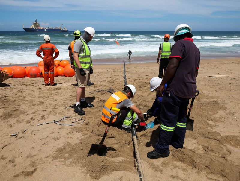 Workers install the 2Africa undersea cable on the beach in Amanzimtoti, South Africa, Feb. 7. A China undersea internet cable system is a sign of an intensifying tech war between Beijing and Washington.