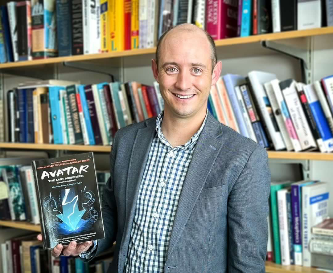 BYU philosophy professor Justin White holds the book "Avatar: The Last Airbender and Philosophy" in his office in Provo on Wednesday. He wrote a chapter about the character Zuko, where he explored identity and change.