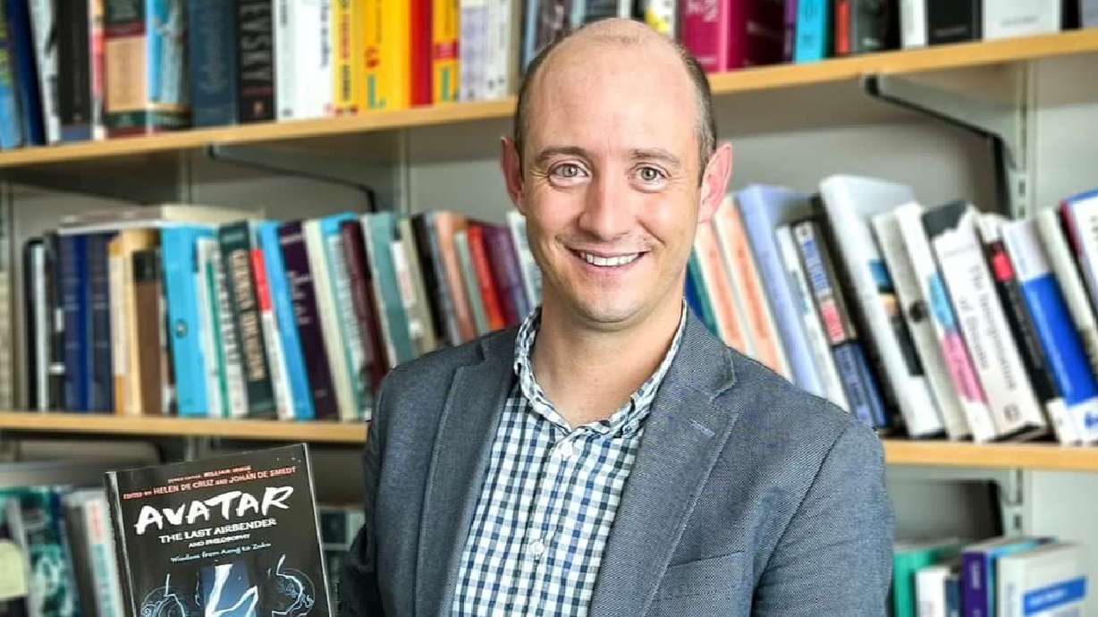 BYU philosophy professor Justin White holds the book "Avatar: The Last Airbender and Philosophy" in his office in Provo on Wednesday. He wrote a chapter about the character Zuko, where he explored identity and change.