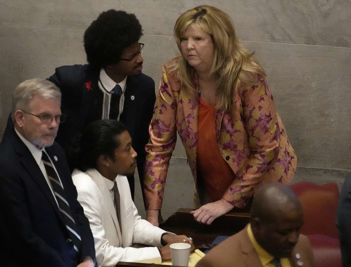 Rep. Justin Jones, D-Nashville, center, Rep. Justin Pearson, D-Memphis, back left and Rep. Gloria Johnson, D-Knoxville, huddle on the floor of the House chamber Thursday, in Nashville, Tenn.