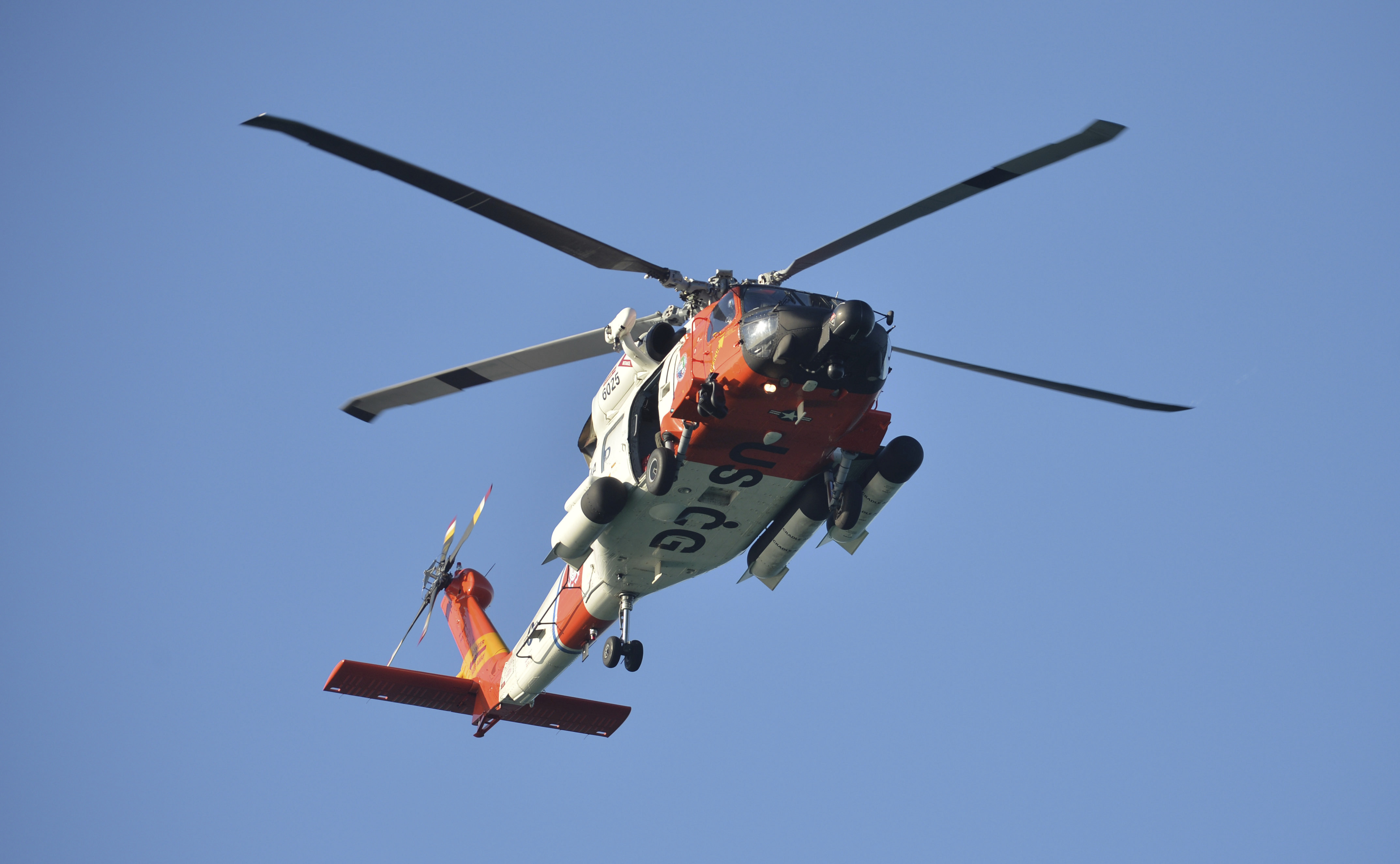 A U.S. Coast Guard helicopter flies over the Venice Fishing Pier Thursday morning as emergency crews search a debris field in the Gulf of Mexico after a small airplane crash Wednesday night. 