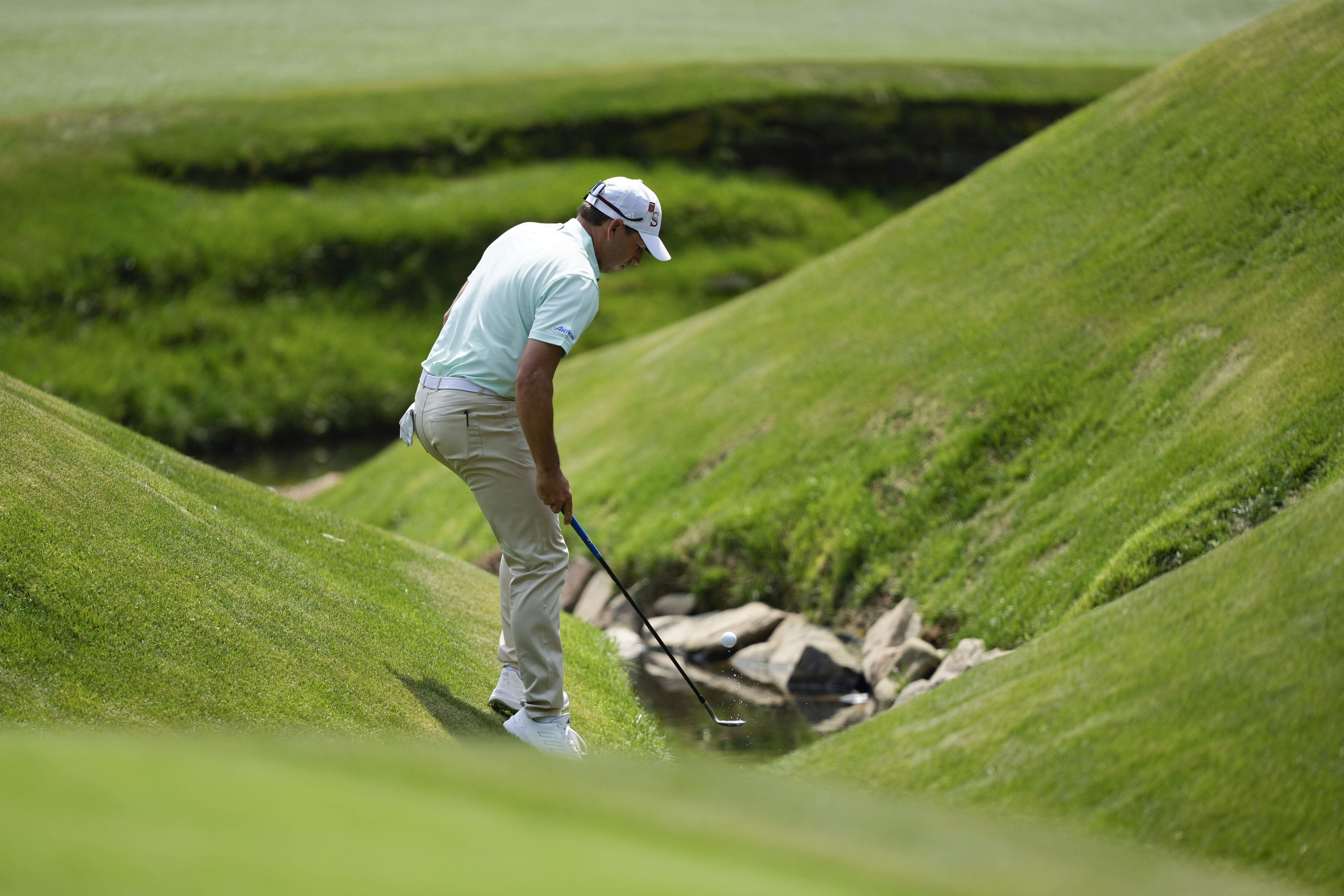 Sergio Garcia, of Spain, fishes his ball out of the creek on the 13th hole during the first round of the Masters golf tournament at Augusta National Golf Club on Thursday, April 6, 2023, in Augusta, Ga. 