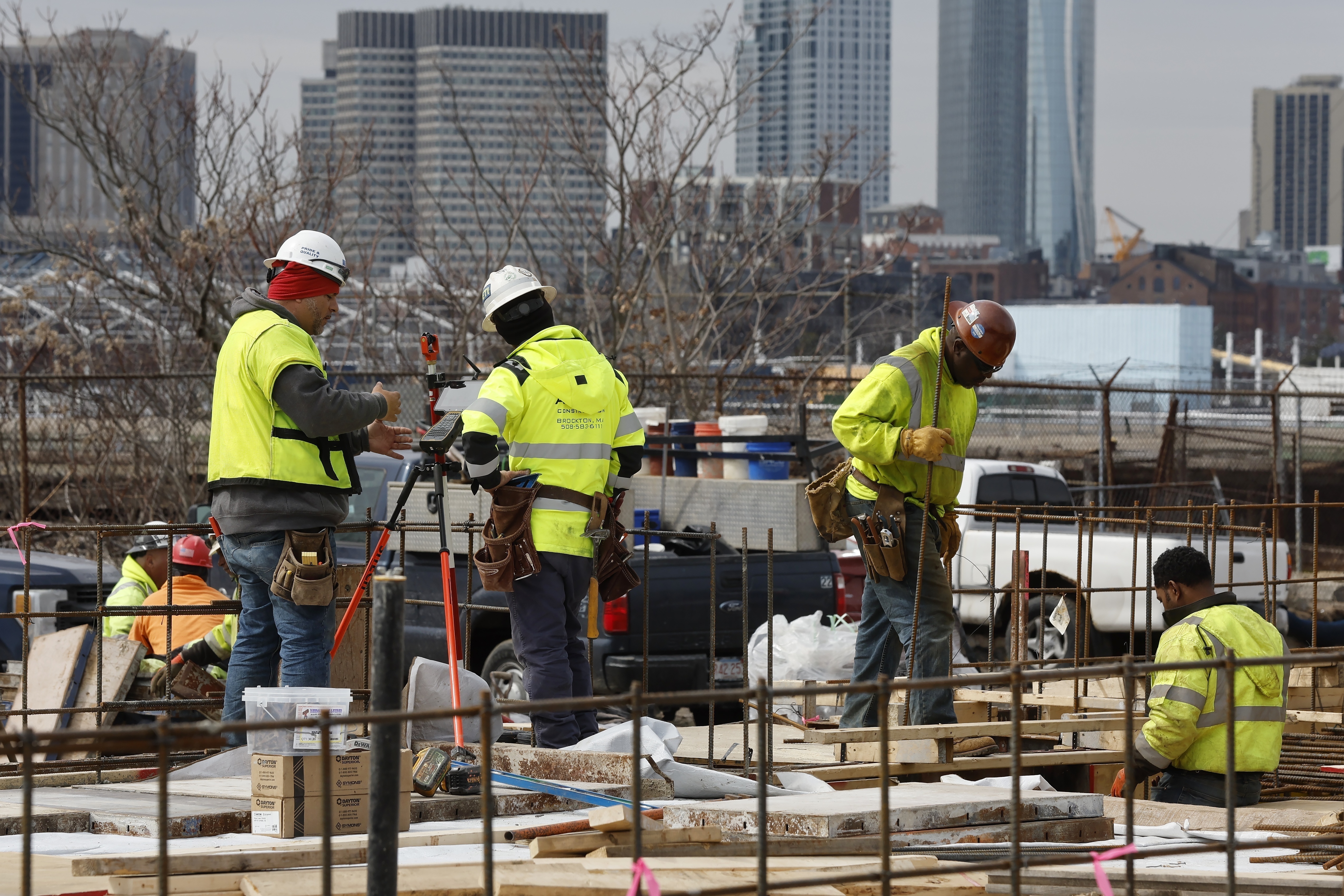 Construction workers prepare a recently poured concrete foundation, March 17, in Boston. On Friday, the U.S. government issues the March jobs report.
