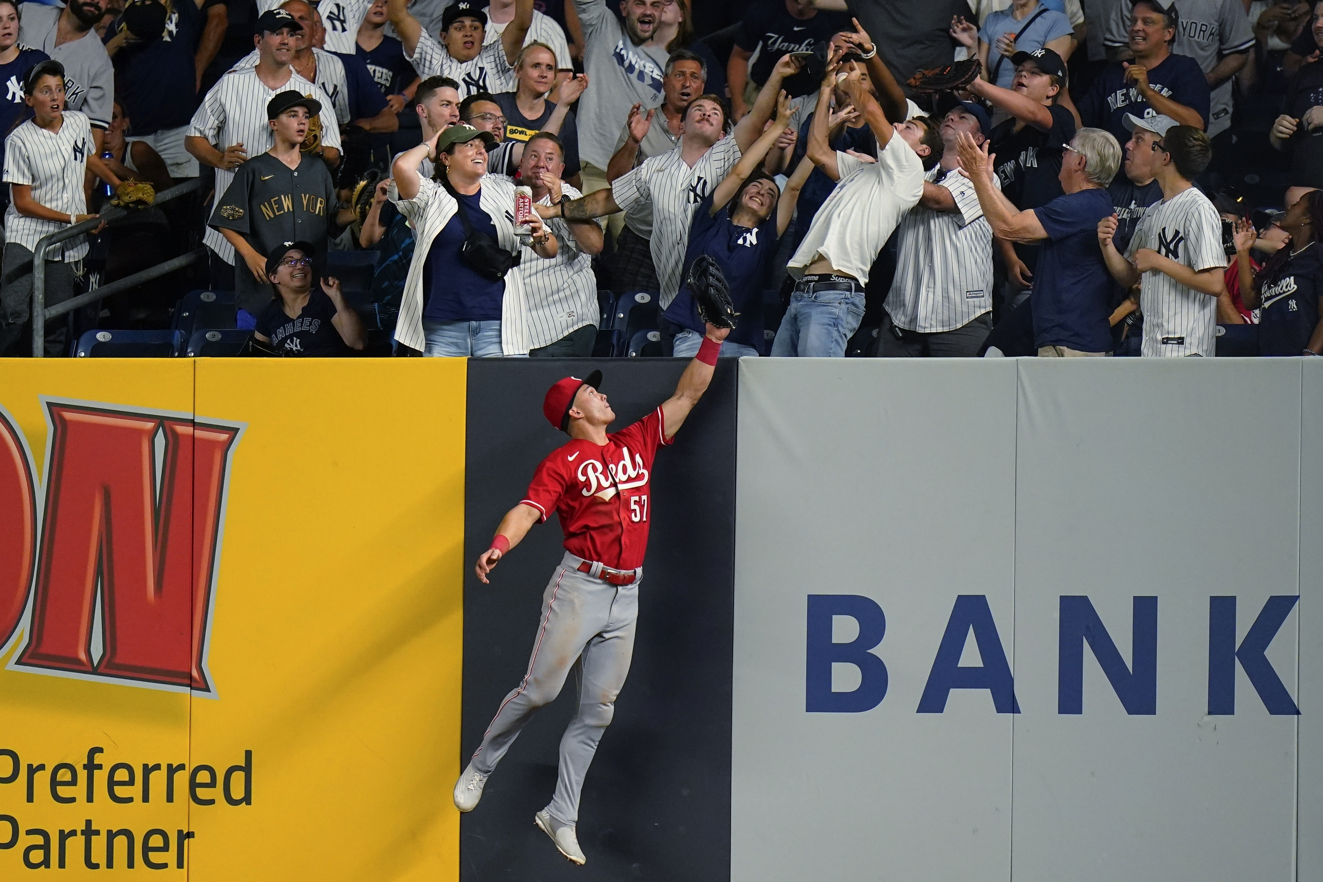 Cincinnati Reds' Stuart Fairchild (57) chases a ball hit by New York Yankees' Giancarlo Stanton for a home run July 13, 2022, in New York. A new study released Friday finds that climate change is making major league sluggers into even hotter hitters, sending an extra 50 or so home runs a year over the fences. 
