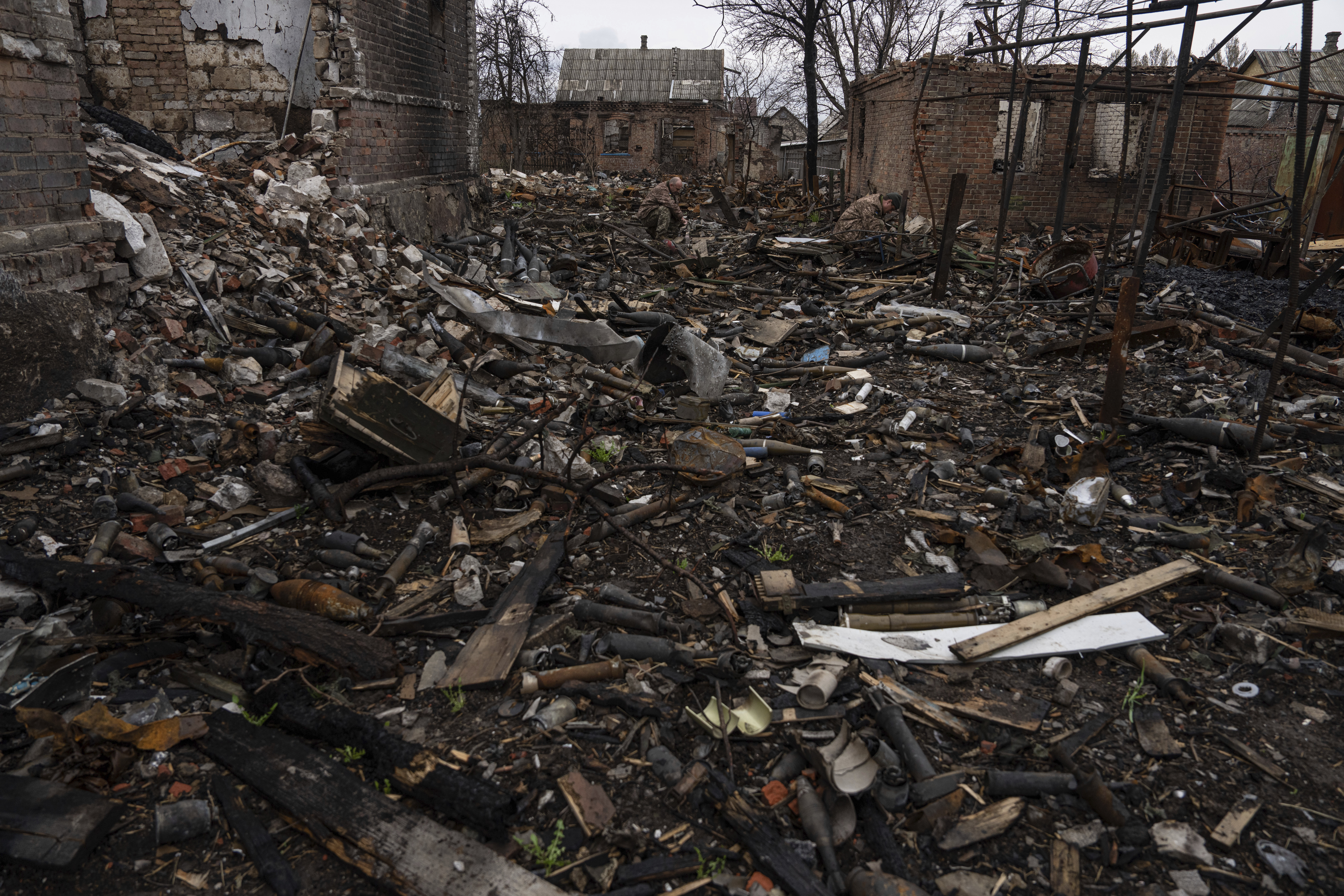 Ukrainian servicemen try to find undamaged shells in a burned-out ammunition depot which was destroyed after Russian attack near Kostiantynivka, Ukraine, Thursday.