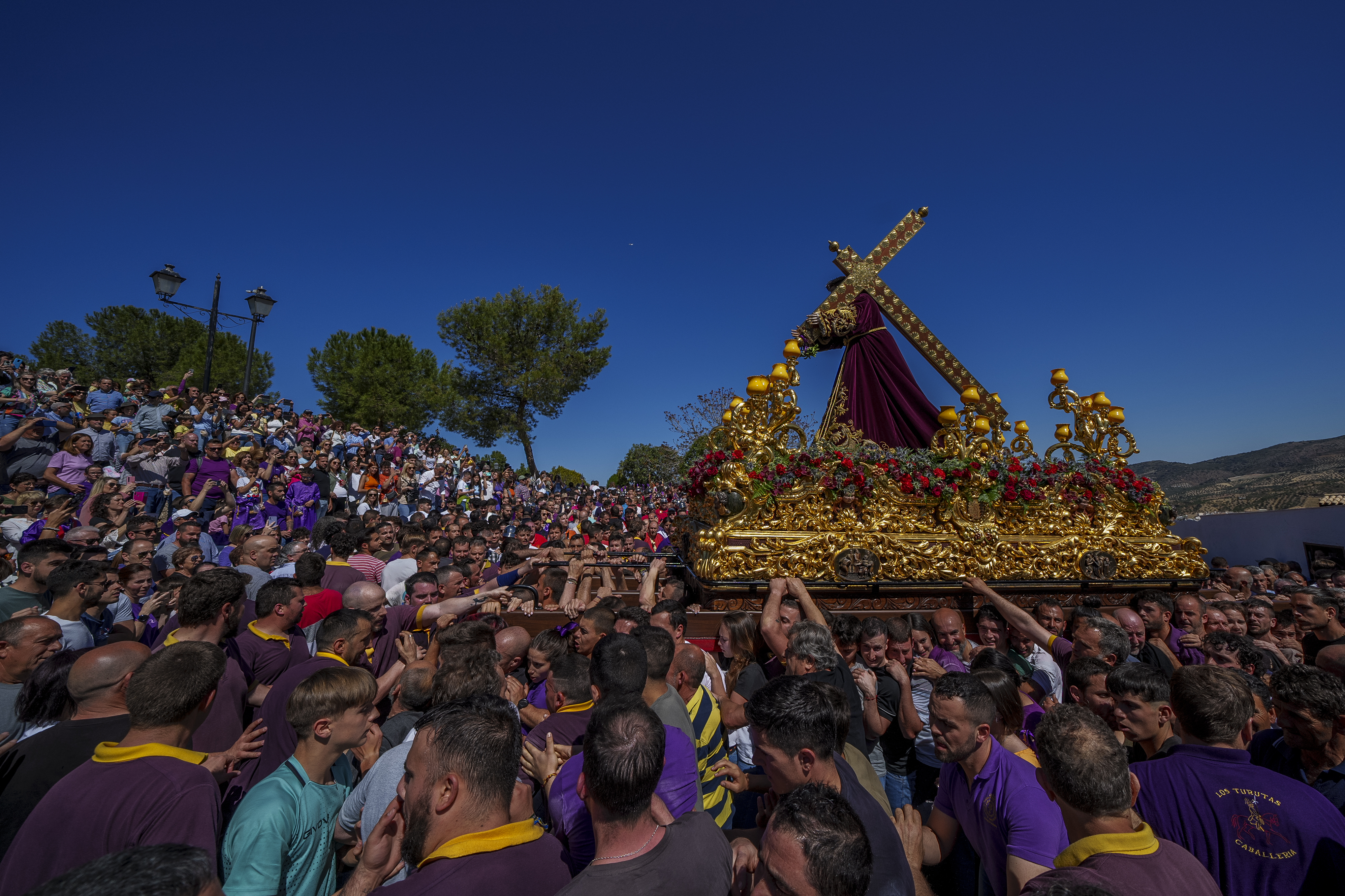 Penitents of the "Padre Jesus Nazareno" brotherhood carry a portable dais platform which supports a statue of Jesus Christ carried by "costaleros" during the holy week procession in Priego de Cordoba, southern Spain, Friday.