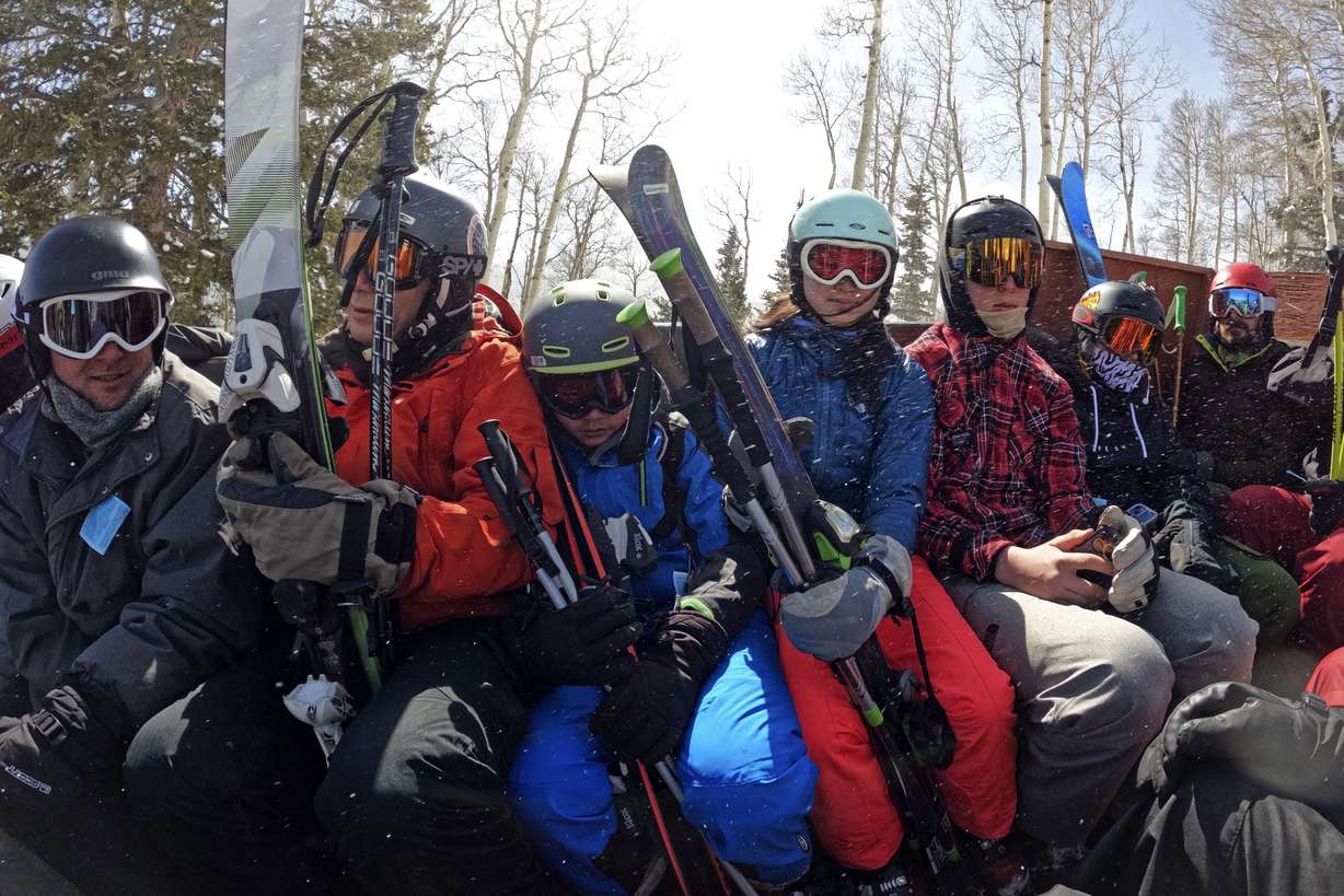 Skiers ride a trailer retrofitted with old bus seats at Parker-Fitzgerald Cuchara Mountain Park on March 19, near Cuchara, Colo. Some communities including Cuchara are now finding a niche, offering an alternative to endless lift lines and sky-high ticket prices. They're reopening, several as nonprofits, offering a mom-and-pop experience at a far lower cost than mountains run by corporate conglomerates.