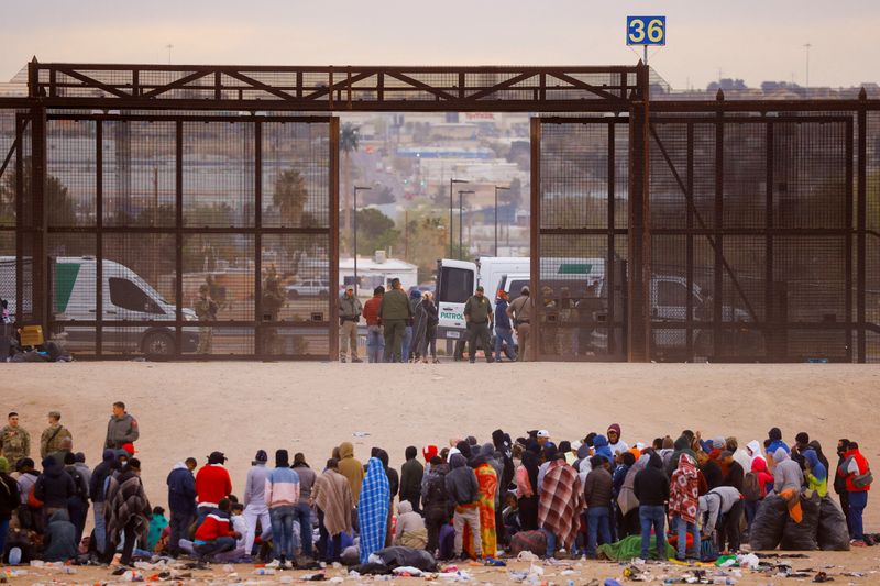 Migrants stand near the border wall after crossing the Rio Bravo river with the intention of turning themselves in to the U.S. Border Patrol agents, as seen from Ciudad Juarez, Mexico, on March 30.