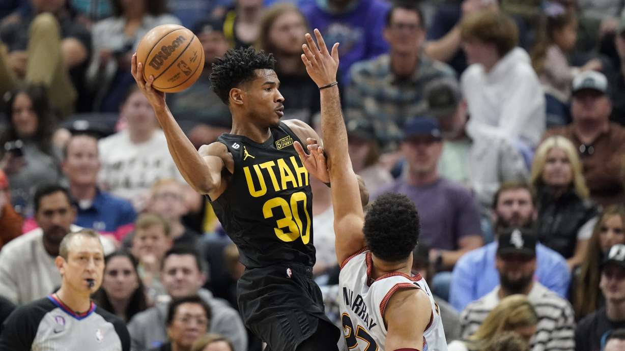 Utah Jazz guard Ochai Agbaji (30) passes the ball as Denver Nuggets guard Jamal Murray (27) defends during the first half of an NBA basketball game Saturday, April 8, 2023, in Salt Lake City.