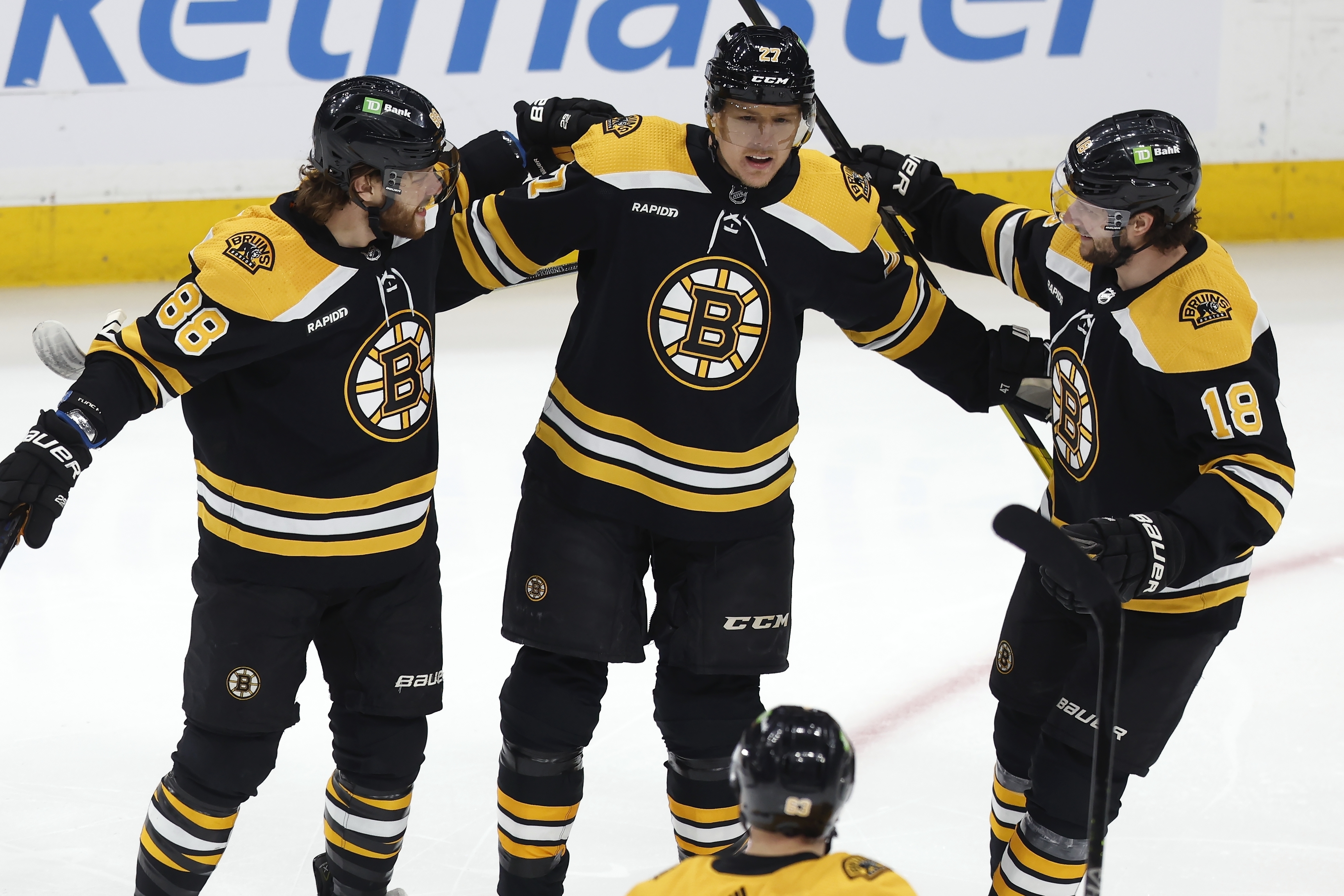 Boston Bruins' Pavel Zacha (18) celebrates with David Pastrnak (88), Hampus Lindholm (27) and Brad Marchand (63) after his first goal during the first period of the team's NHL hockey game against the New Jersey Devils, Saturday, April 8, 2023, in Boston. 
