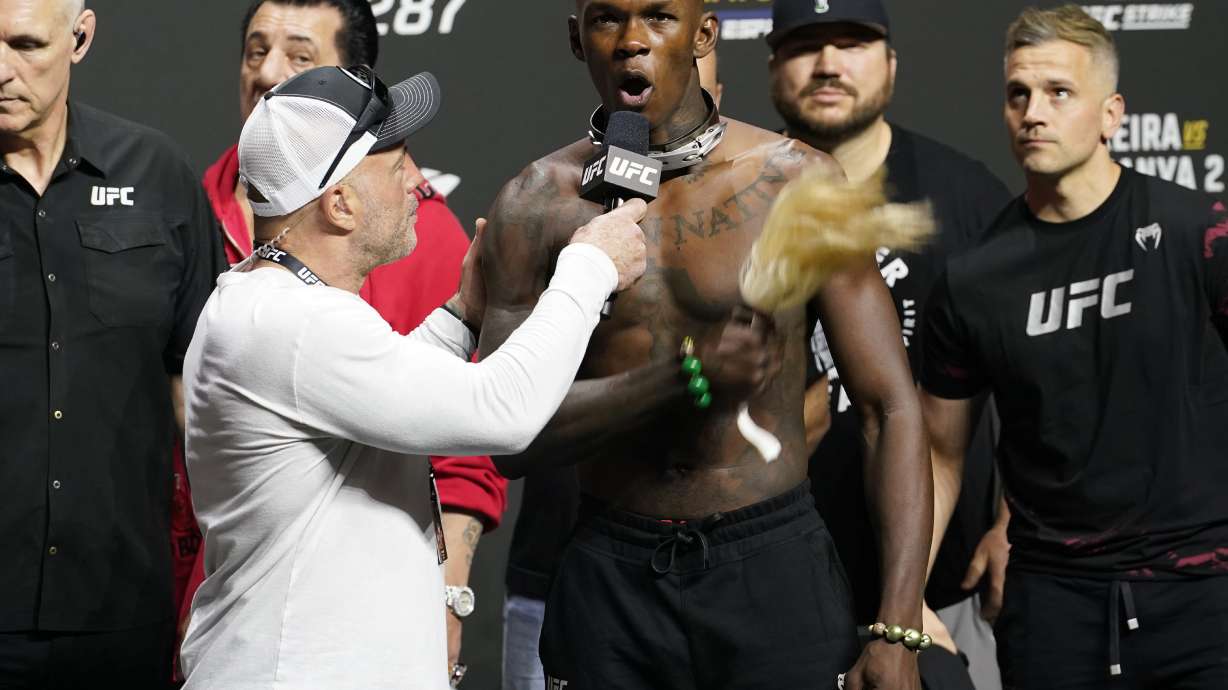 UFC commentator Joe Rogan, front left, listens to Israel Adesanya after a ceremonial weigh-in Friday, April 7, 2023, in Miami. Adesanya will face UFC 287 middleweight champion Alex Pereira on Saturday.