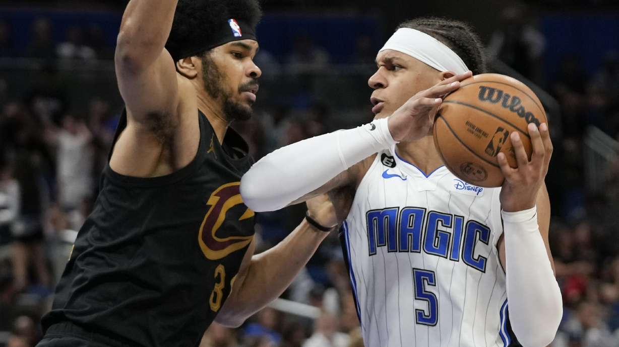 Orlando Magic's Paolo Banchero (5) makes a move to get past Cleveland Cavaliers Jarrett Allen during the second half of an NBA basketball game, Tuesday, April 4, 2023, in Orlando, Fla.