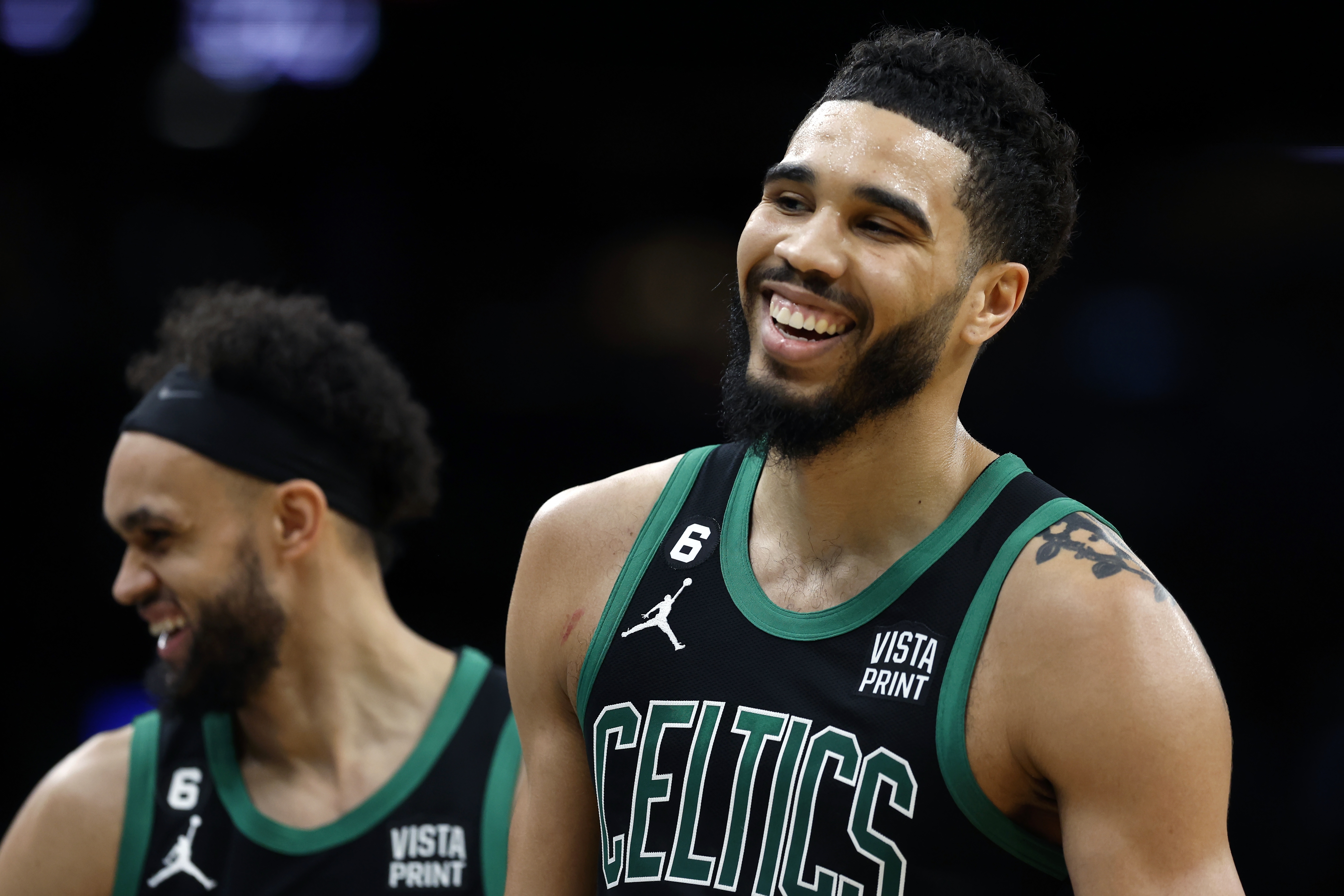 Boston Celtics' Jayson Tatum, right, and Derrick White react during the first half of the team's NBA basketball game against the Toronto Raptors, Friday, April 7, 2023, in Boston. 