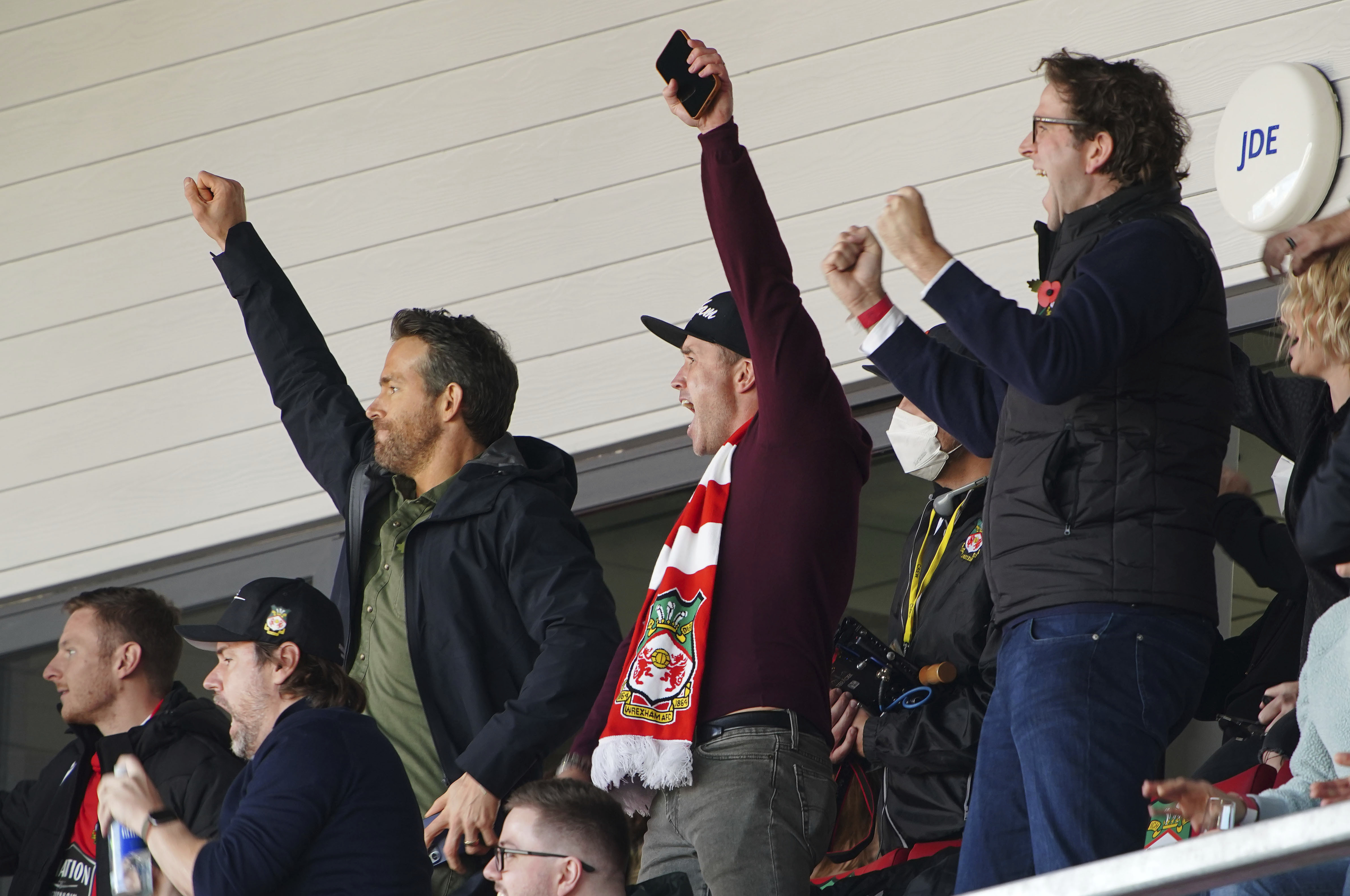 FILE - Wrexham owners, Ryan Reynolds, center left and Rob McElhenney, center, celebrate their side's first goal of the game, scored by Harry Lennon during the Vanarama National League match against Torquay United, at the Racecourse Ground, Wrexham, England, on Oct. 30, 2021. Soccer sensation Wrexham AFC is coming to America. The fifth-tier Welsh side, which has become a global fan favorite since Hollywood stars Reynolds and McElhenney bought it and then launched a documentary series, "Welcome to Wrexham," will play Manchester United in a friendly on July 25, 2023. 